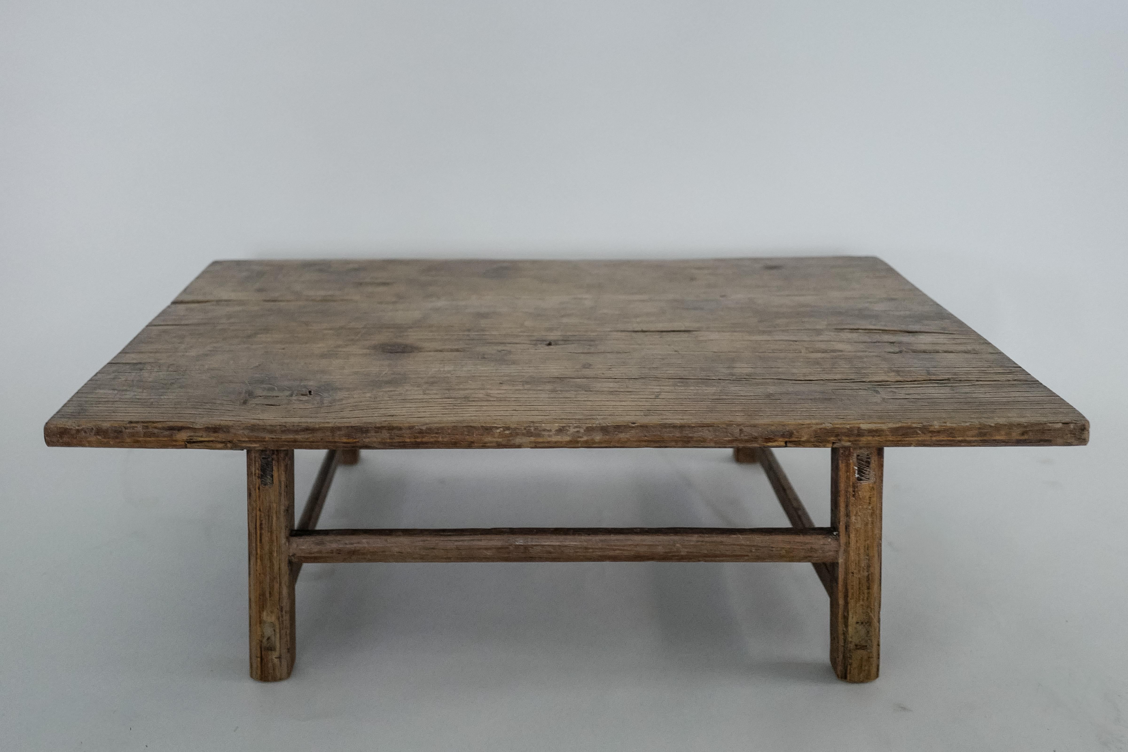 Cette table basse ancienne en orme chinois du XIXe siècle incarne l'essence du design provincial chinois, avec ses détails authentiques réalisés à la main et sa belle patine développée au fil du temps. Fabriquée en bois d'orme massif, la forme