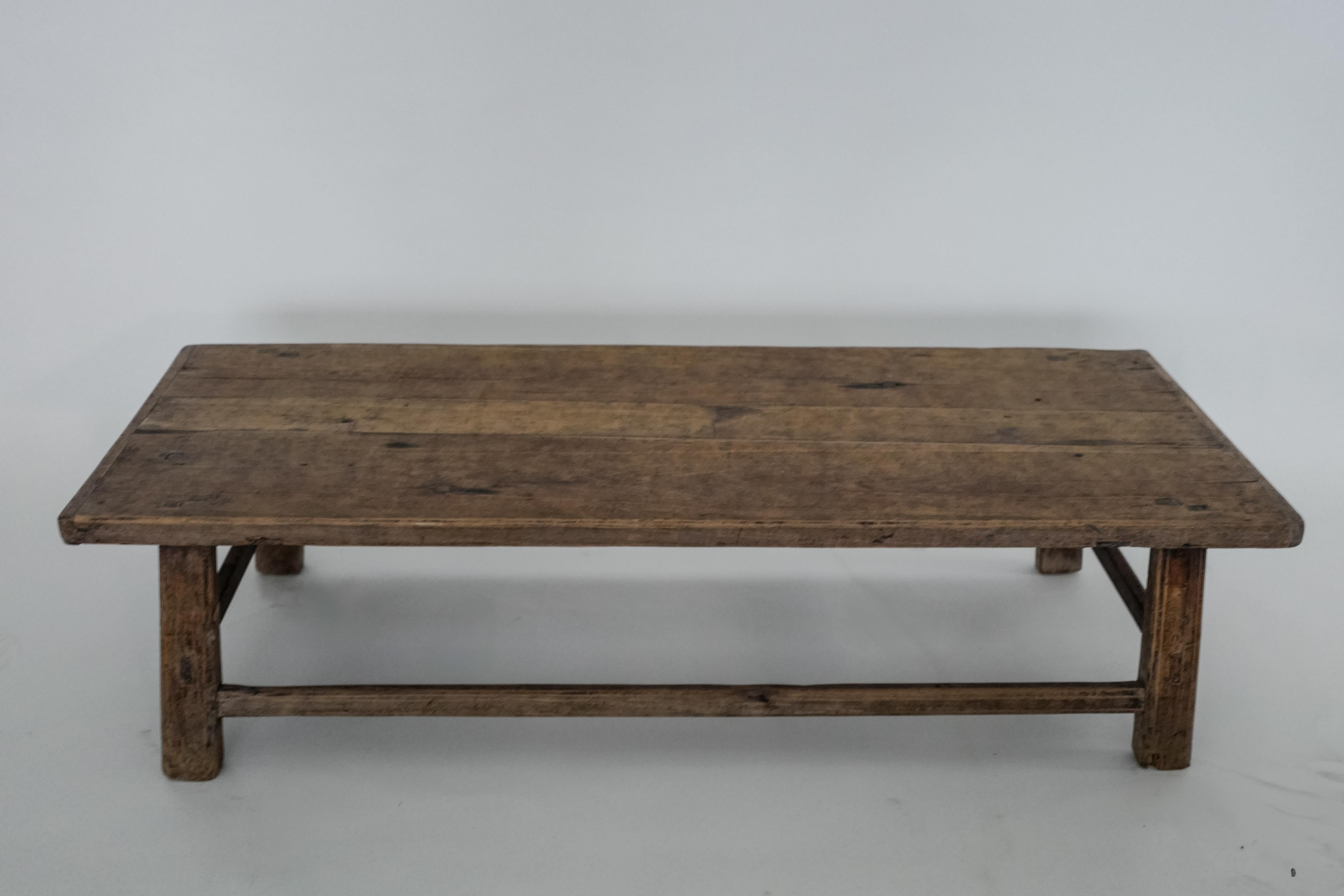 This 19th-century Chinese coffee table is a stunning example of Chinese Provincial craftsmanship, made from solid elm wood with an original, time-worn finish. Its simple rectangular shape and sturdy construction speak to the functional beauty of