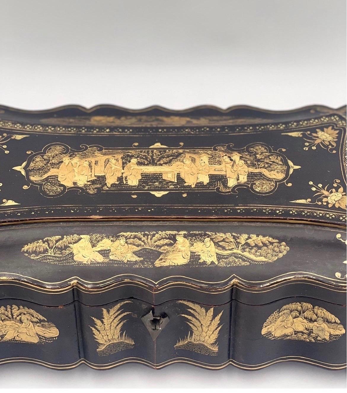 Rare form for this 19th century chinese export lacquer decorated glove or jewelry box. With finely carved wood foo dog feet.