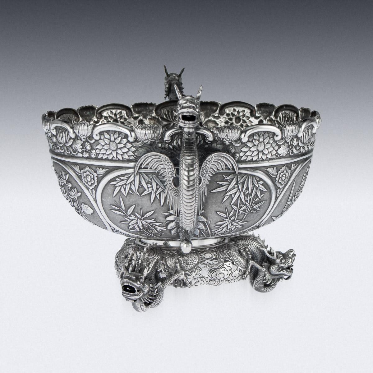 Antique late 19th century Chinese solid silver decorative dragon bowl, of round form with an embossed floral rim, matted ground decorated with four panels. Depicting blossoming cherry trees, chrysanthemums, bamboo and water lilies. The bowl applied
