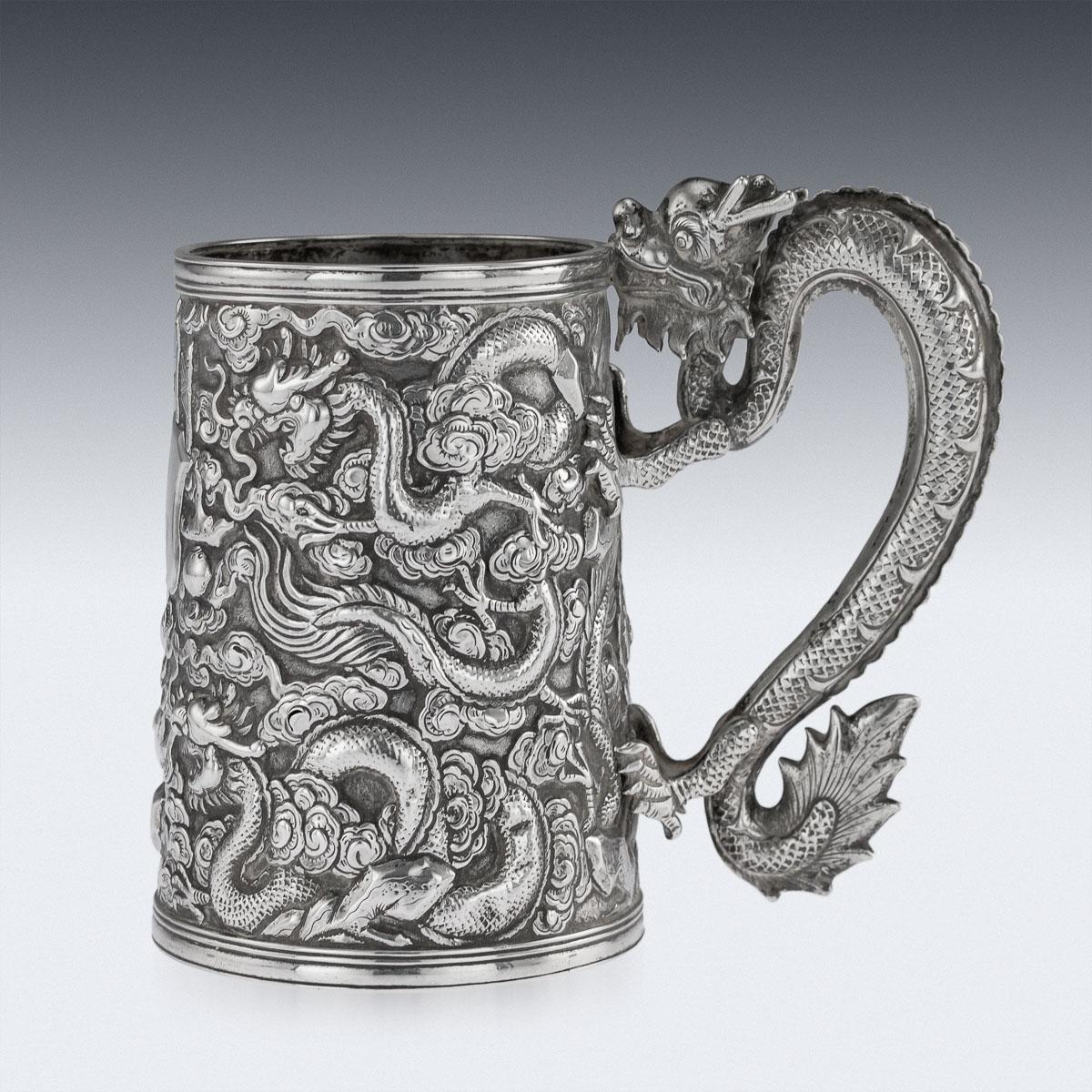 Antique 19th century Chinese export solid silver mug, tapering form, the double walled body is beautifully decorated in relief with dragons amongst clouds, very crisp and detailed, centering a shield engraved with elaborate initials, the handle is