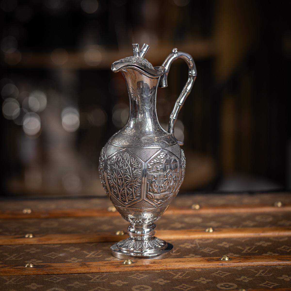 Antique 19th Century Chinese Export solid silver wine ewer of exceptional quality. Of baluster form, the piece showcases a remarkable combination of traditional Chinese silverwork techniques and decorative styles. The domed circular base is chased