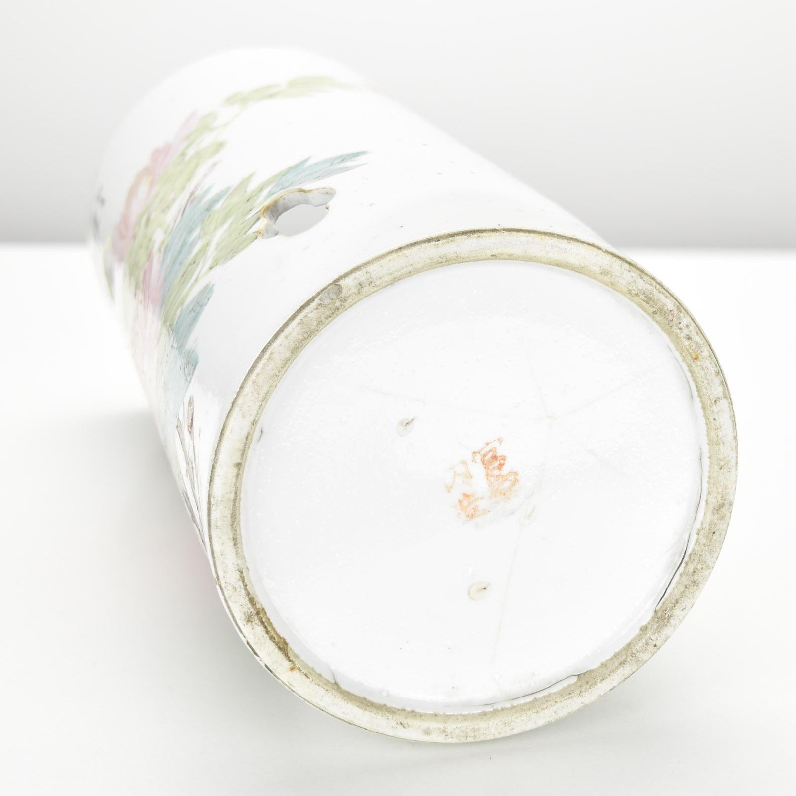 This exquisite antique Chinese hat stand, also used as a lantern, is a fine example of Famille Rose porcelain, possibly Republican Period. The cylindrical porcelain piece features hand-painted motifs of a bird perched on a flowering branch,