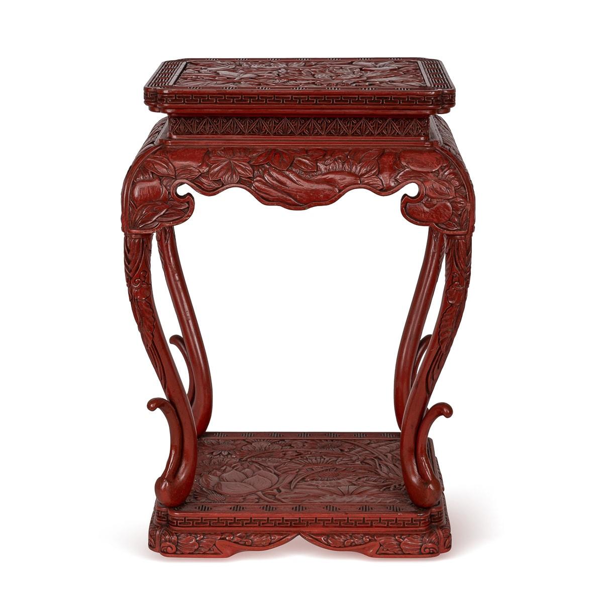 An exquisite 19th Century Chinese red lacquer pedestal table. Crafted in a square shape with gracefully curved legs that merge seamlessly with the base, it captivates all who encounter it. Adorned with deeply carved lotus flowers and flowing floral
