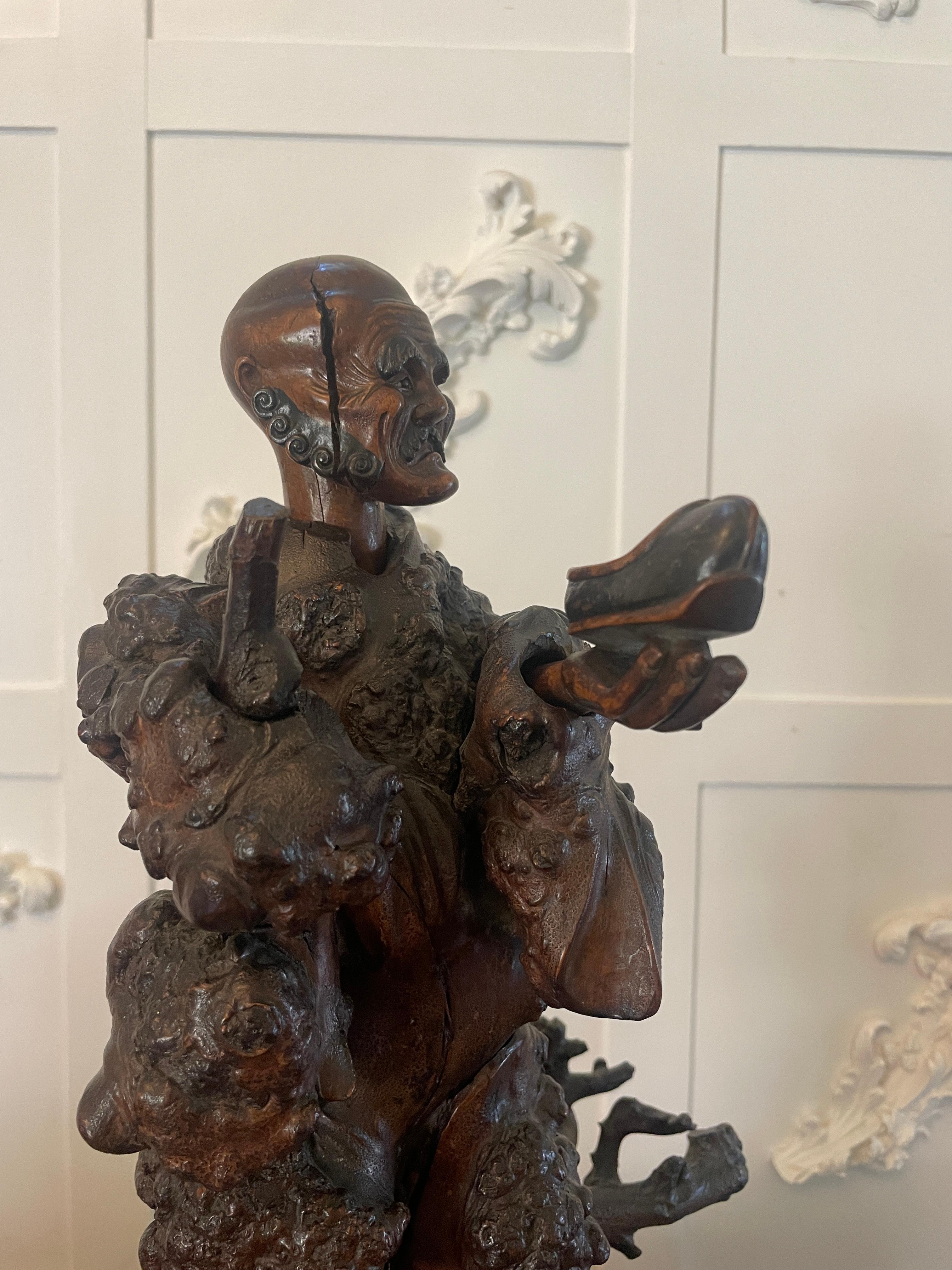 Antica scultura cinese del XIX secolo raffigurante un venditore ambulante che tiene in mano una scarpa sollevata da rami splendidamente intagliati. I dettagli e la qualità dell'intaglio sono squisiti. 


Il dettaglio dell'intaglio è favoloso, così