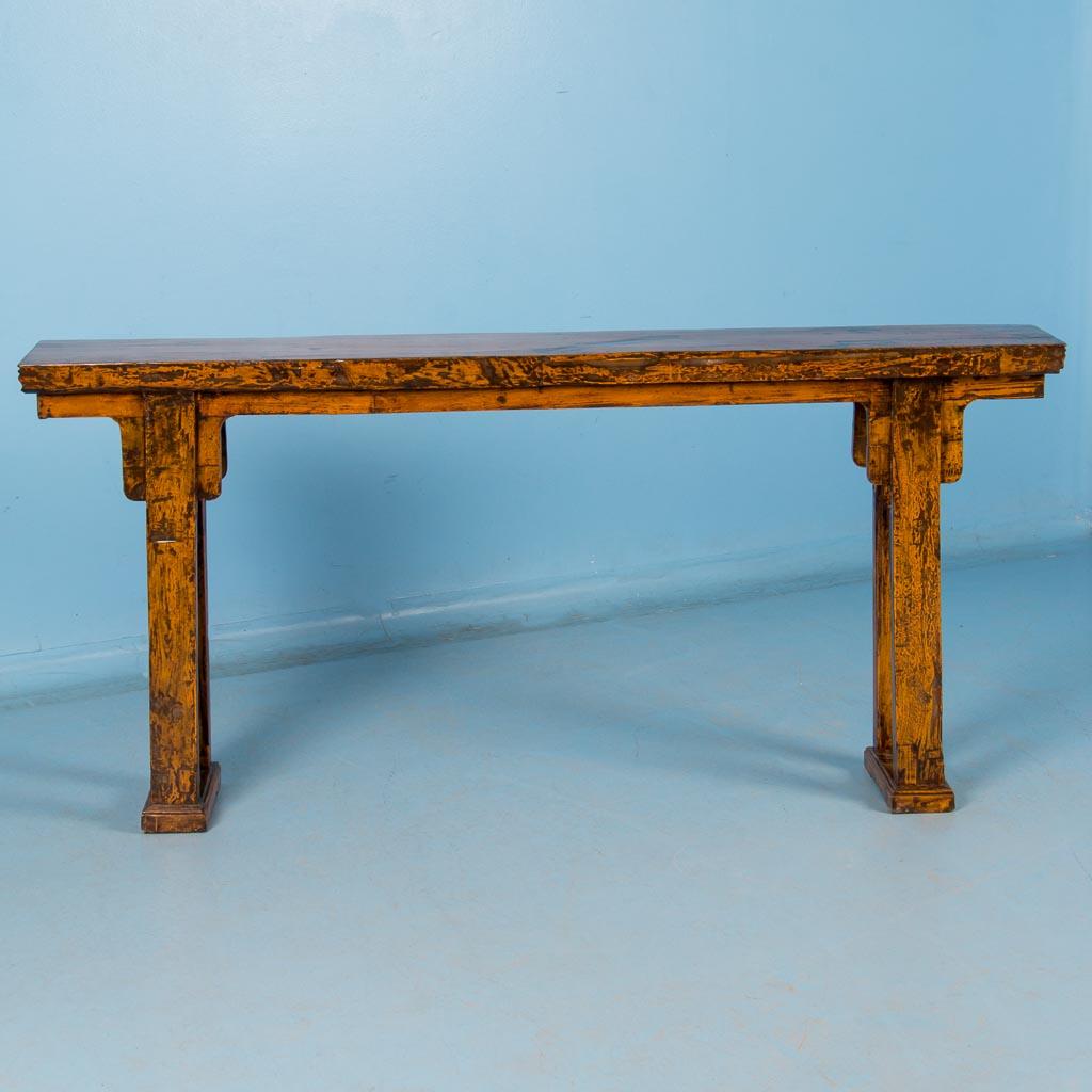 Antique yellow lacquered altar table from China, circa 1840-1860. The natural wood color offers a wonderful contrast to the amber color of the paint. At just over six feet long and almost 12