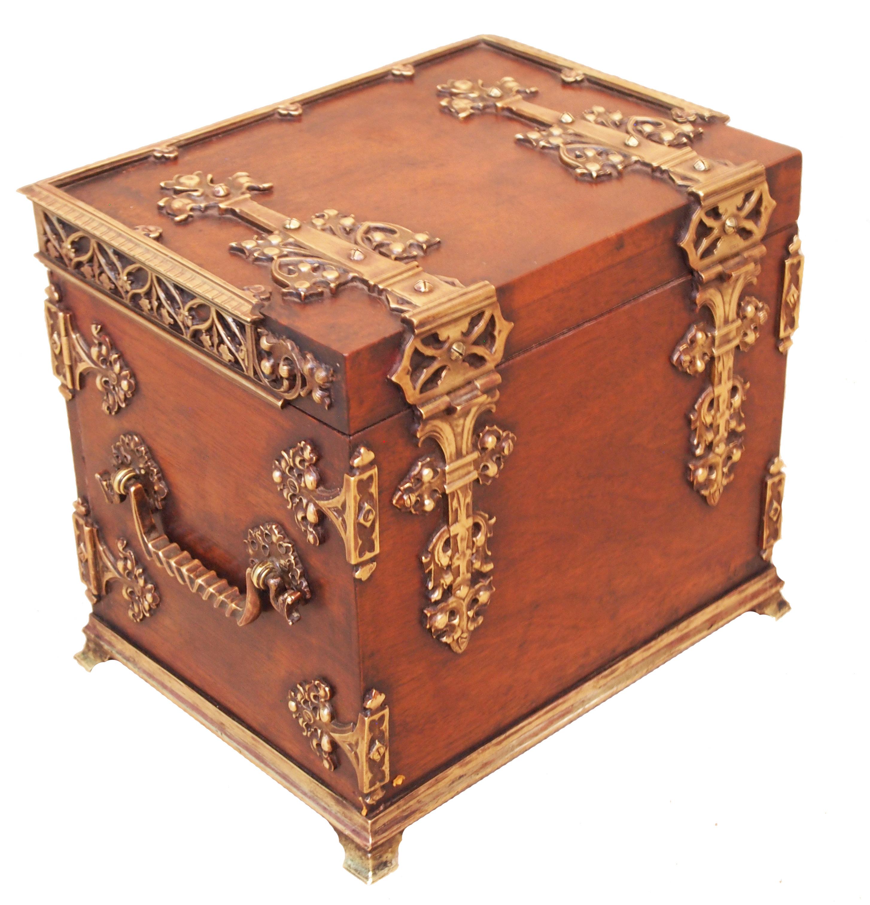 A fine quality mid-19th century walnut cigar humidor box in
the Gothic taste having decorative Ormolu strap work
decoration to lift up lid and pair of doors enclosing cigar
slides raised on later brass ogee feet.