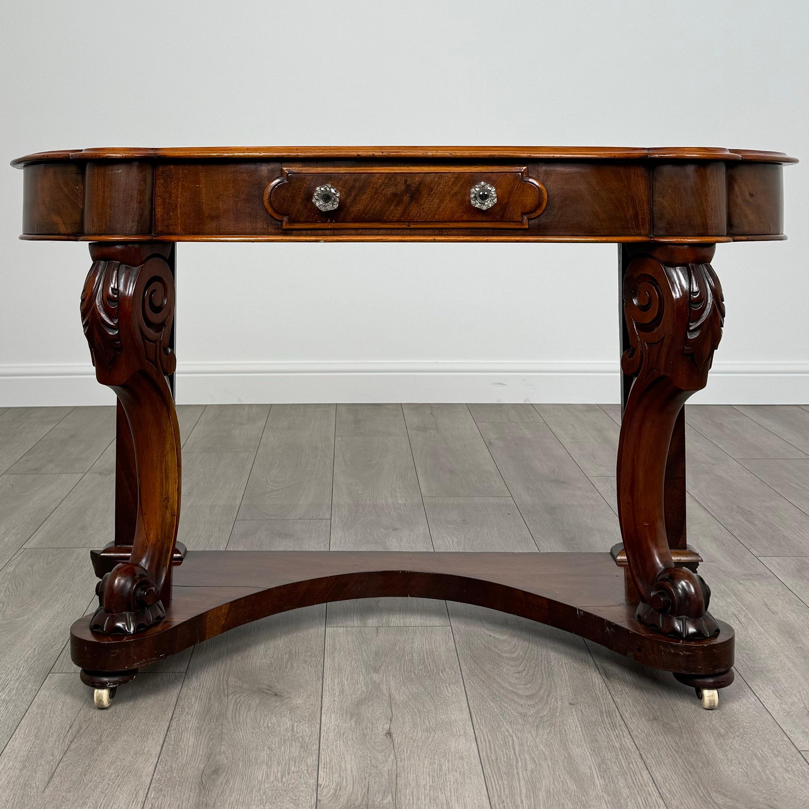 An exquisite 19th-century mahogany console table of excellent quality, featuring a rare and unusual small size that adds to its unique charm. 
The table stands gracefully on two front cabriole legs, complemented by a practical lower shelf and