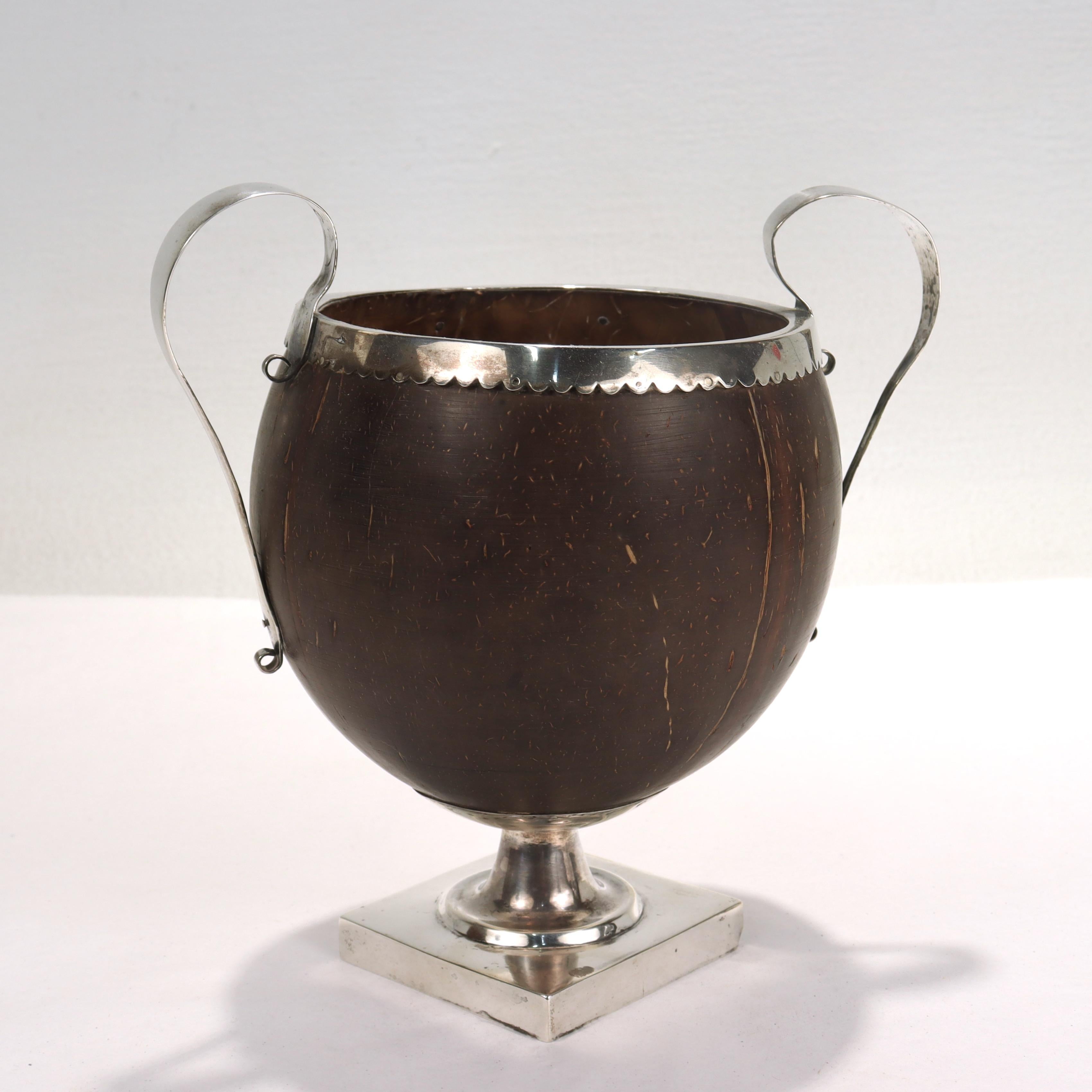 A fine antique 19th Century Anglo-Indian footed cup. 

Comprising a coconut shell with a stepped silver foot, scalloped rim, and shaped handles.

Unmarked for maker or fineness.

Simply a wonderful rare object!

Date:
19th Century

Overall