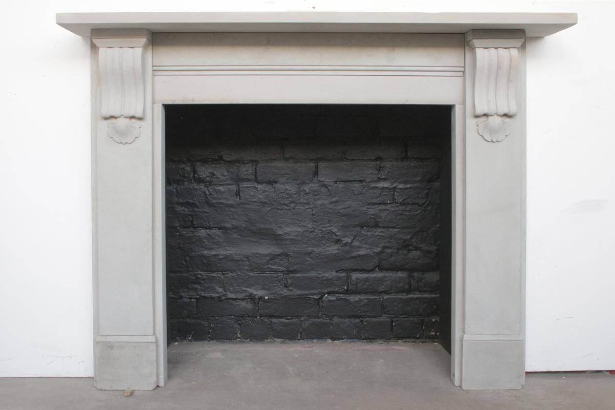 Antique 19th-century corbelled fireplace surround in pale grey stone, with sharp and well carved corbels supporting the shelf. Typical of this grey gritstone, occasional carbon deposits can be seen throughout this fireplace. Removed from a property