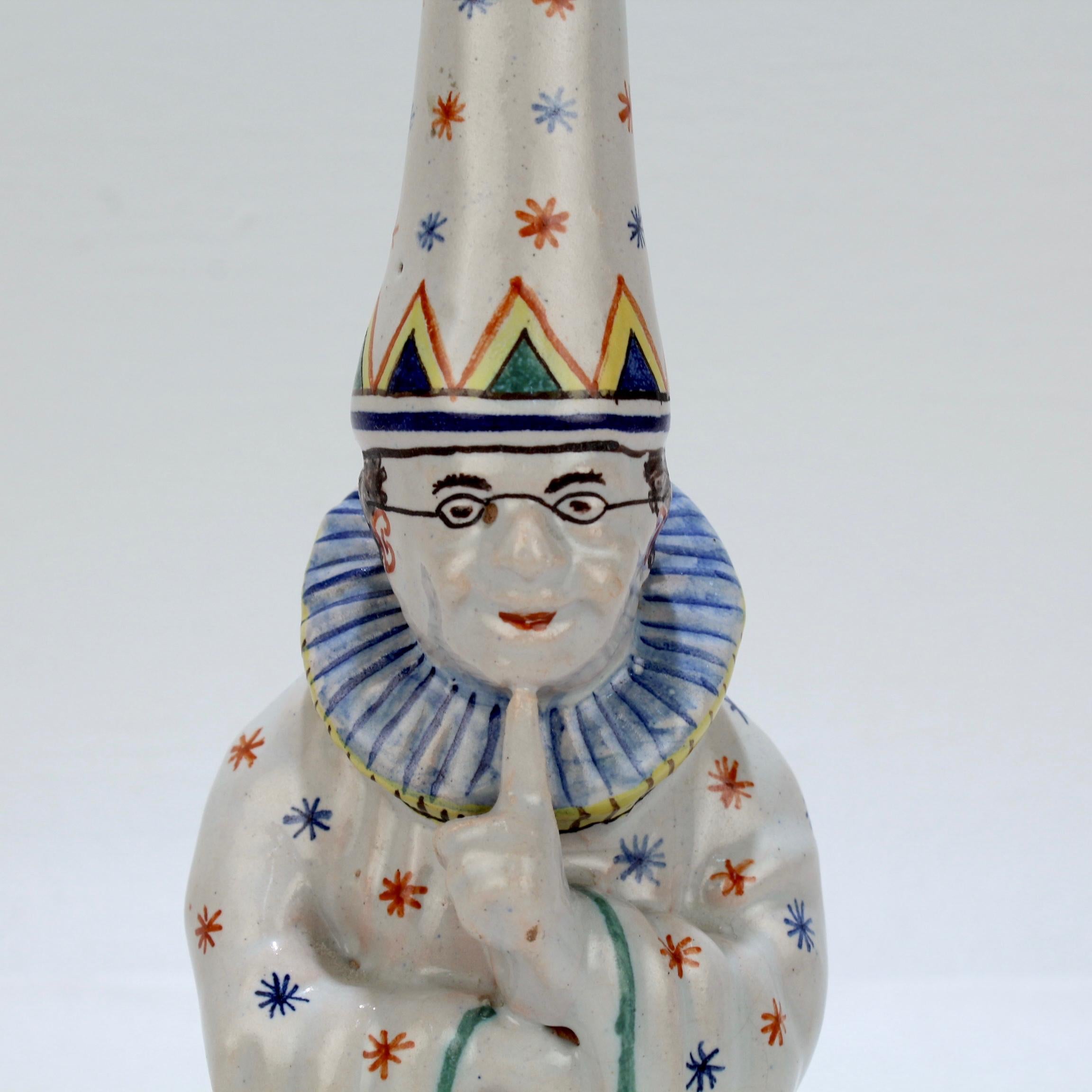 A wonderfully whimsical, figural Desvres faience bell.

In the form of a wizard with splayed clock and wizard's hat shushing the room.

Marked for the Charles Fourmaintraux Courquin factory in underglaze blue.

A truly fun piece of