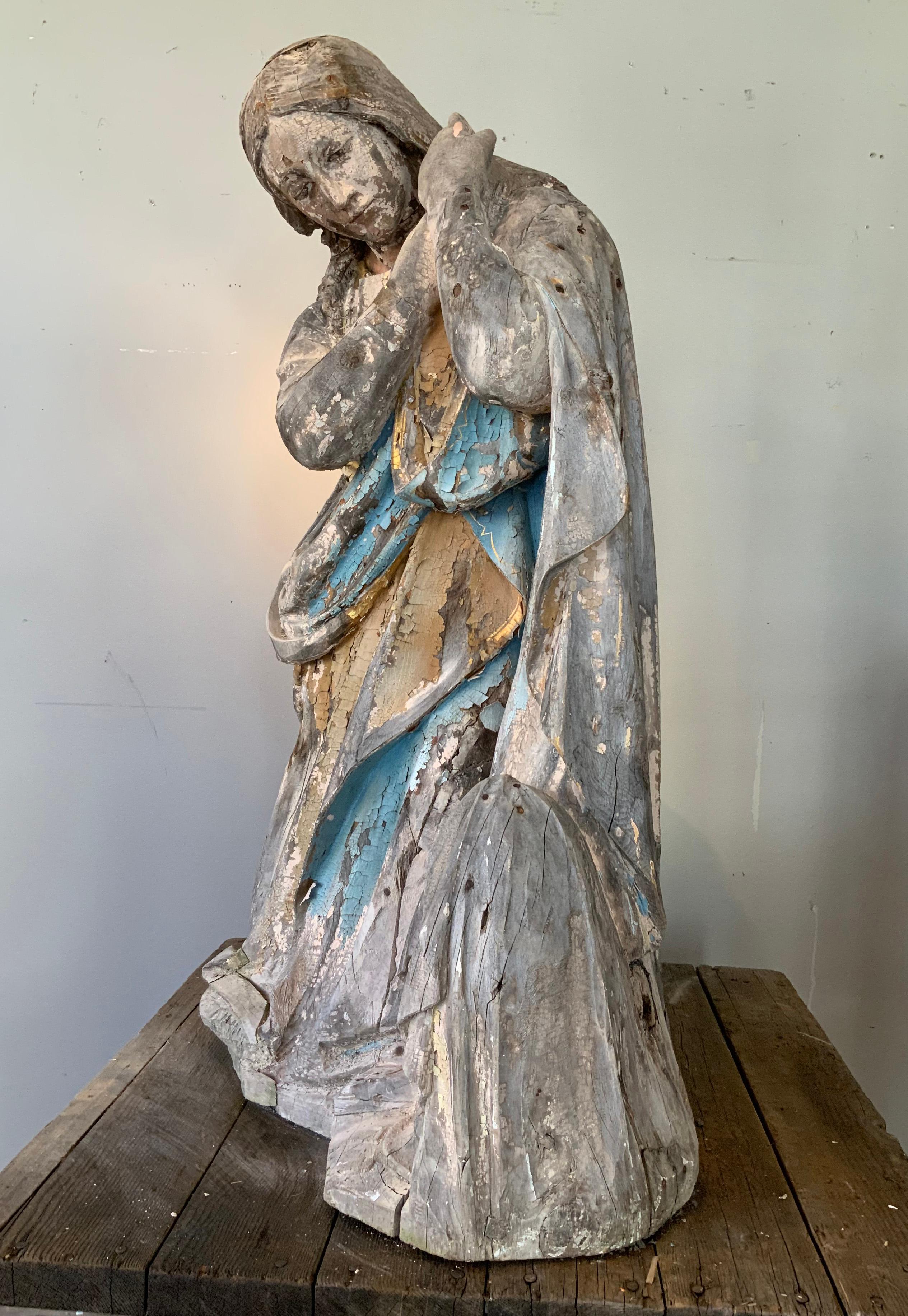 an incredible antique late 19th century carved wood sculpture of a saint figure. the sculpture was originally painted and gilded -- and there are some remnants of the peeling and chipped paint and gilding as well. the wood is split and chipped in