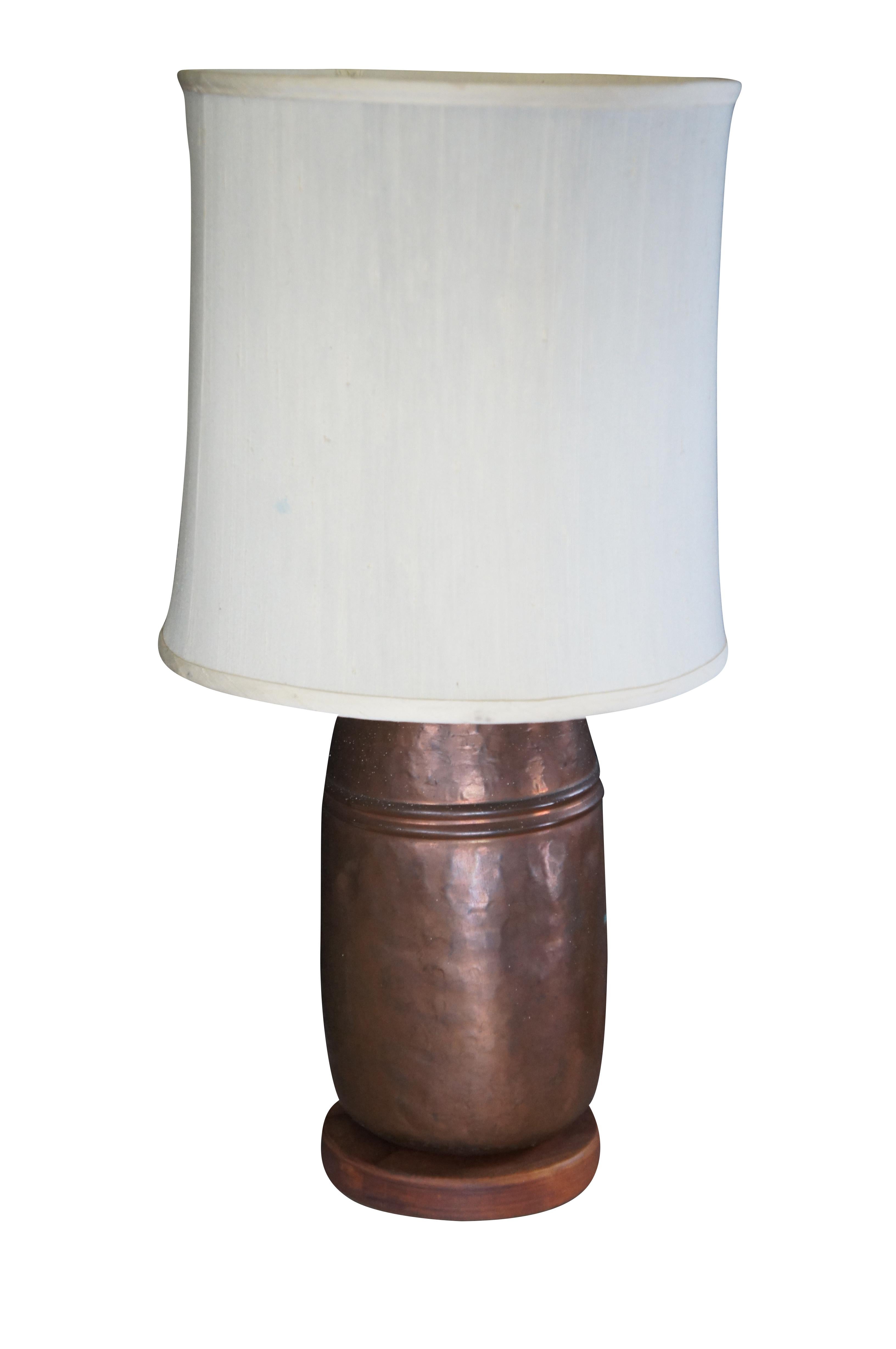 A beautiful antique hammered and dovetailed copper pot or canister table lamp.  The rustic 19th century pot has a unique form and charming patina.  Sits on a wooden plinth base.  The pot was converted to a lamp around 1980.  

Dimensions:
28