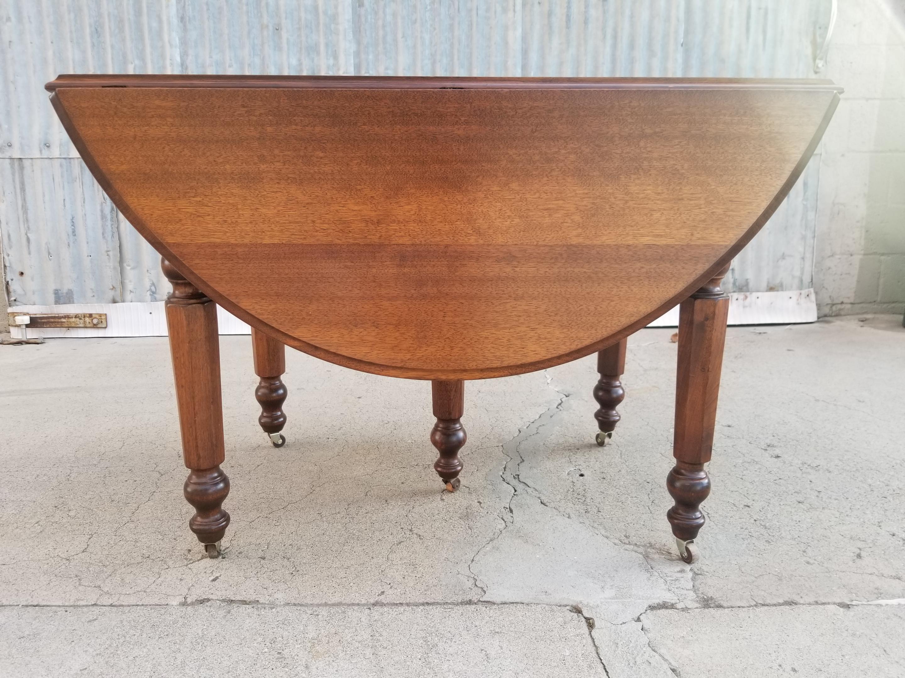 Late 19th century drop-leaf expanding dining table crafted in solid walnut. Includes three 11.5