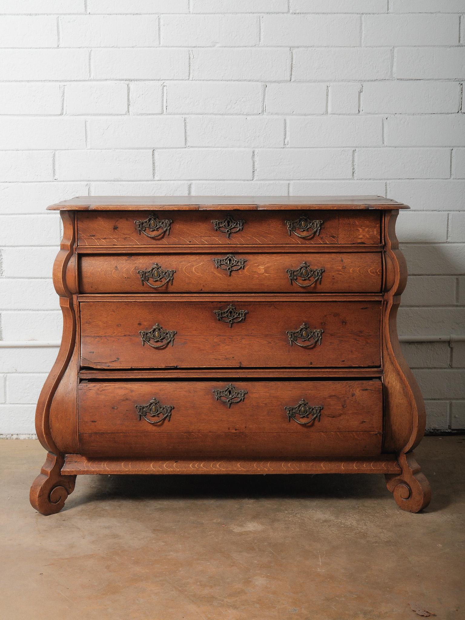 Questa straordinaria cassettiera olandese a bombe del XIX secolo mette in mostra la ricca maestria artigianale e la forma scultorea caratteristica del design dell'Europa continentale. Realizzato a mano in rovere massiccio, il pezzo presenta un