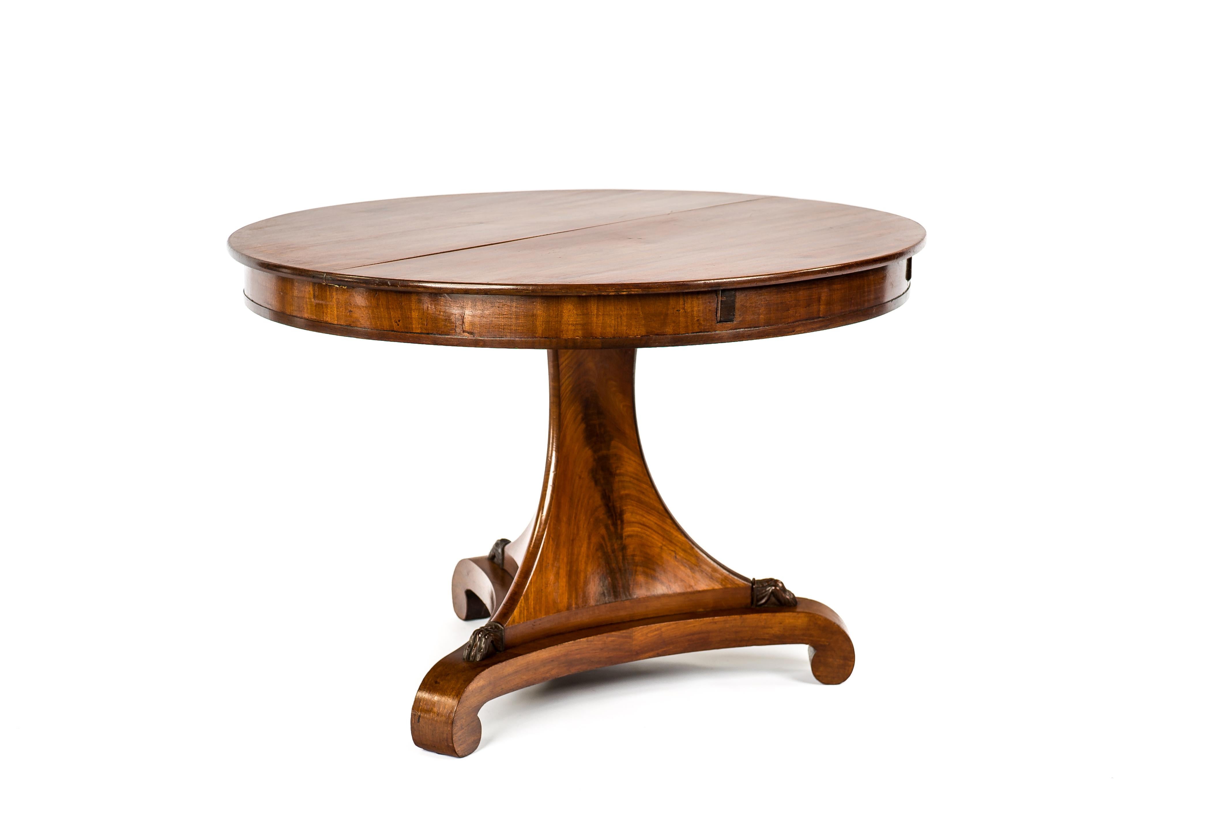 A classic Dutch Empire extension table in beautiful flamed mahogany. The tabletop is made from two sheets of mahogany in a symmetrical open book manner. The table has a solid mahogany top of 0,70 inches. Below is a mahogany veneered apron of 3.15