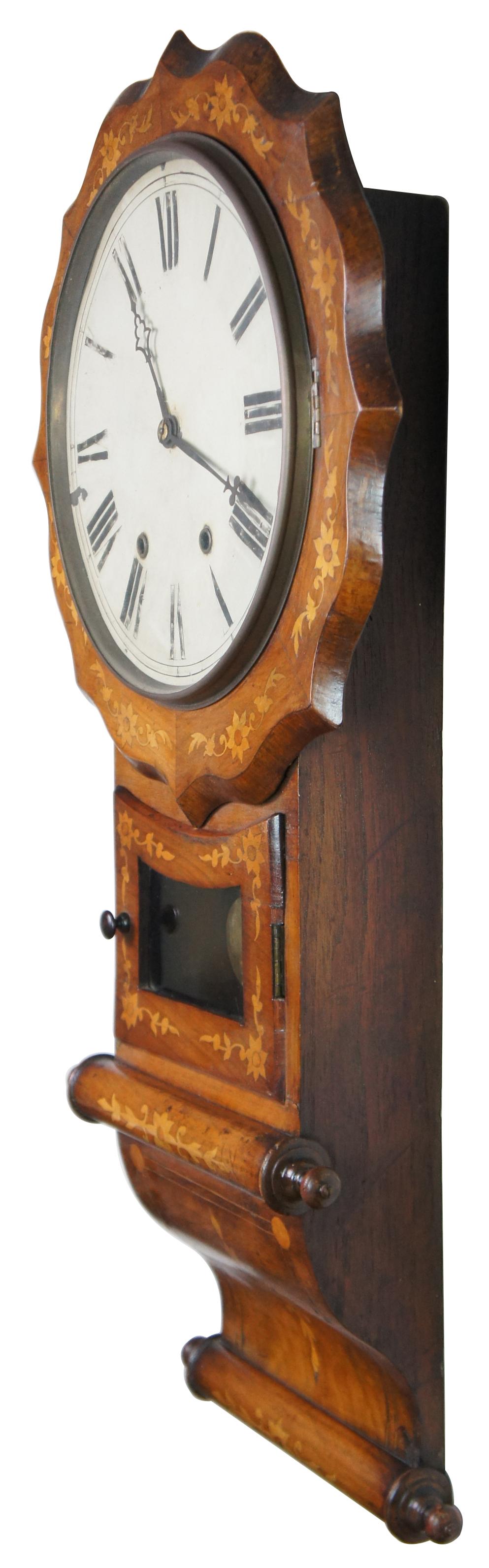 Antique 19th century Anglo American drop dial wall clock. The hand-crafted case being made in England, and the movement being imported from the Us Made of walnut and inlaid satinwood / fruitwood featuring scalloped form with a starburst / sunburst