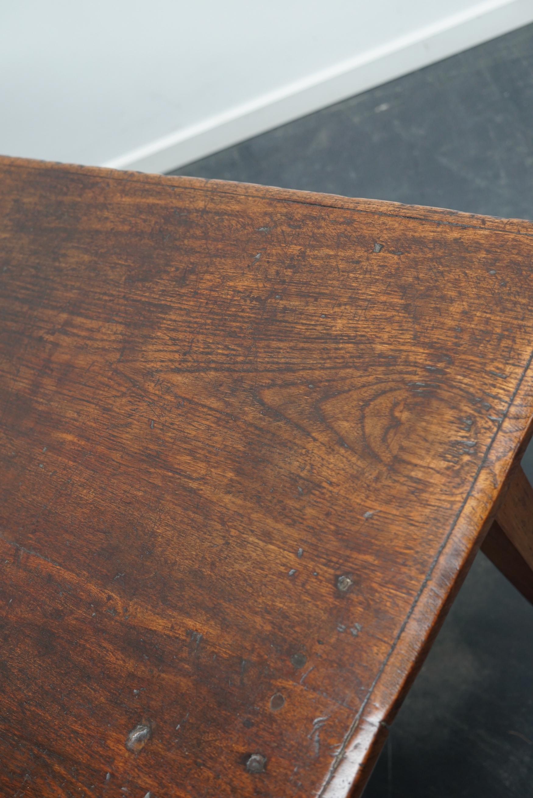 This elegant table was made in the Netherlands / Indonesia in the late 19th century. It has a tabletop made from large slabs of wood. The table was made in solid Indonesian teak with a beautiful grain pattern. It has a warm color with deep gloss and
