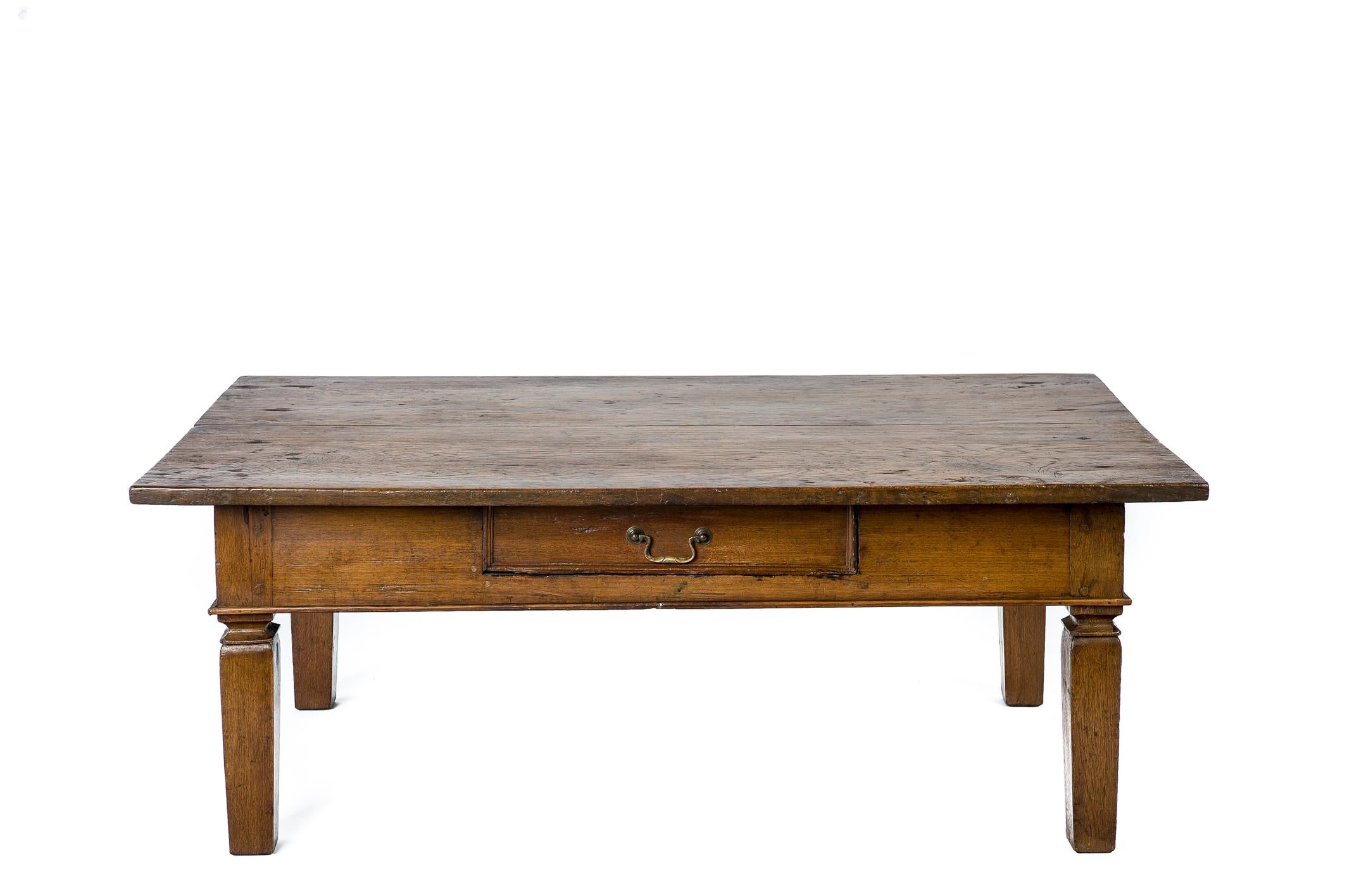 This elegant coffee table was made in the Netherlands in the late 19th century. It has a tabletop made from two wide boards of a solid teak joint together by a lap joint. Below is a single drawer with a simple trim and a brass drawer pull. The table