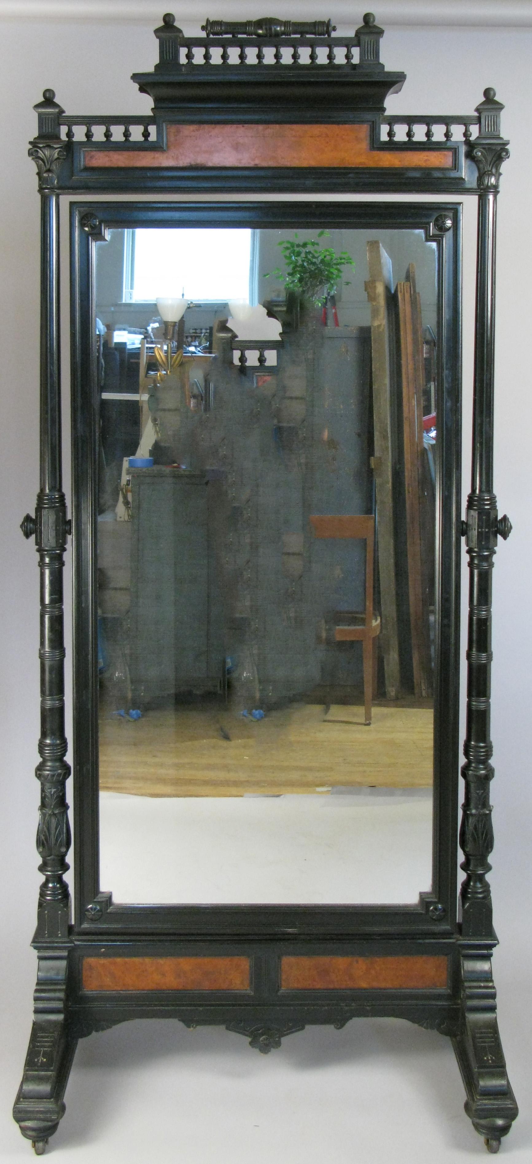 A very handsome 19th century standing cheval mirror, with an ebonized frame and burlwood accents. Beautiful details, design and scale.