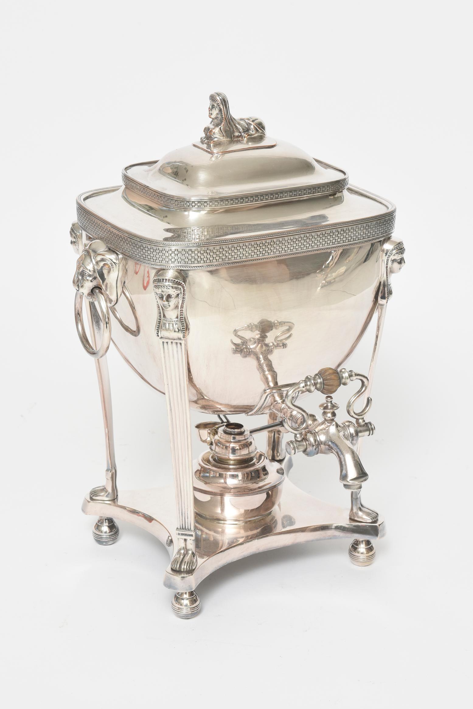 This late 19th century silver plated coffee urn is the perfect example of Egyptian Revival. The lid is adorned with a sphinx at its top. Going down, its beautiful shape is adorned with braided inset borders. Below are lions head ring in mouth
