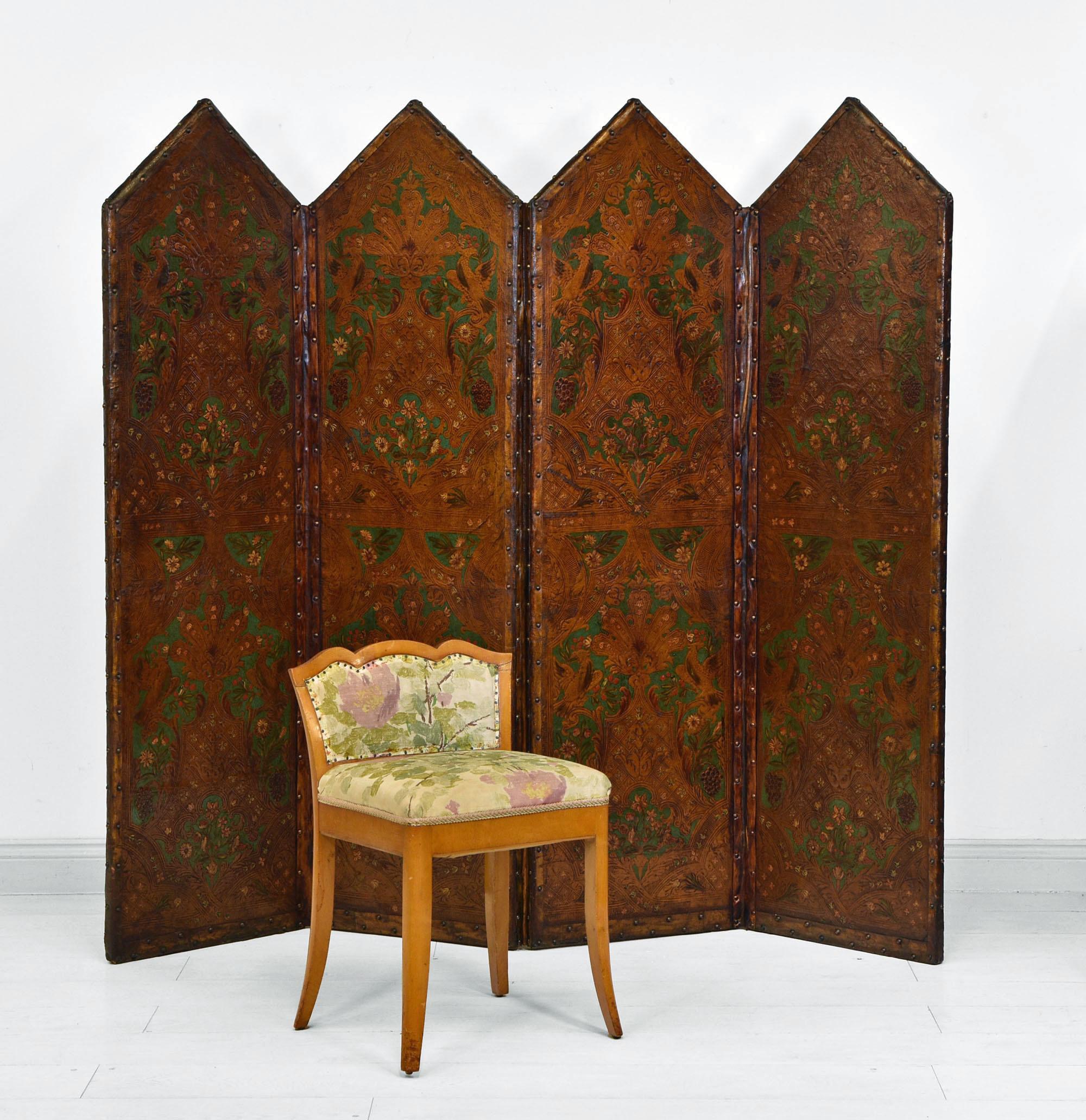 An antique leather embossed and hand painted four fold screen. Circa 1880.

With antique gold/rich umber tones and forest green in colour, it is decorated with mythological birds and classically embossed with hand painted floral decoration.