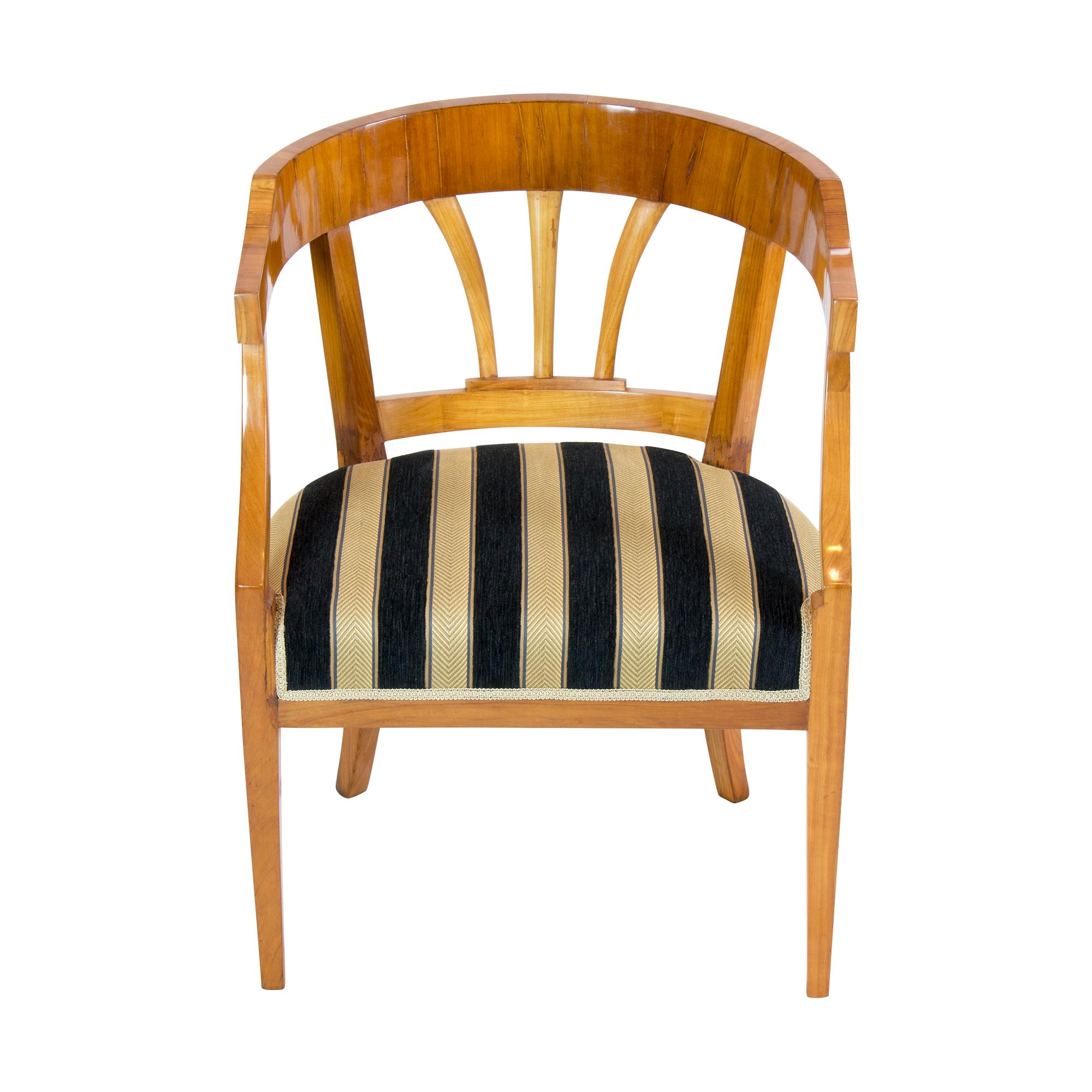 Schöner zeitloser Biedermeier /Empire Sessel aus dem frühen 19. Jahrhundert. Der Sessel wurde aus massiver Kirsche und auch aus furnierter Kirsche hergestellt. Der Rücken ist rund und in der Mitte des Rückens befinden sich 3 Schilfrohre. Die Beine