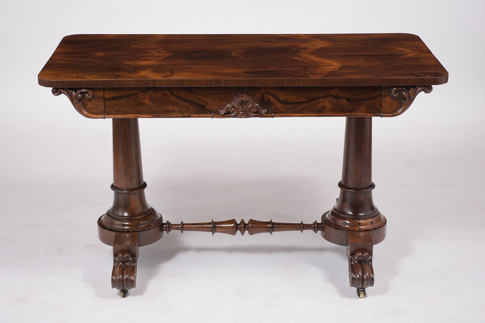 An extraordinary antique empire desk hand-crafted out of beautiful rosewood and professionally restored by our team of expert craftsmen. This writing table features a rectangular wooden top two drawers with a carved shell in the middle and molding
