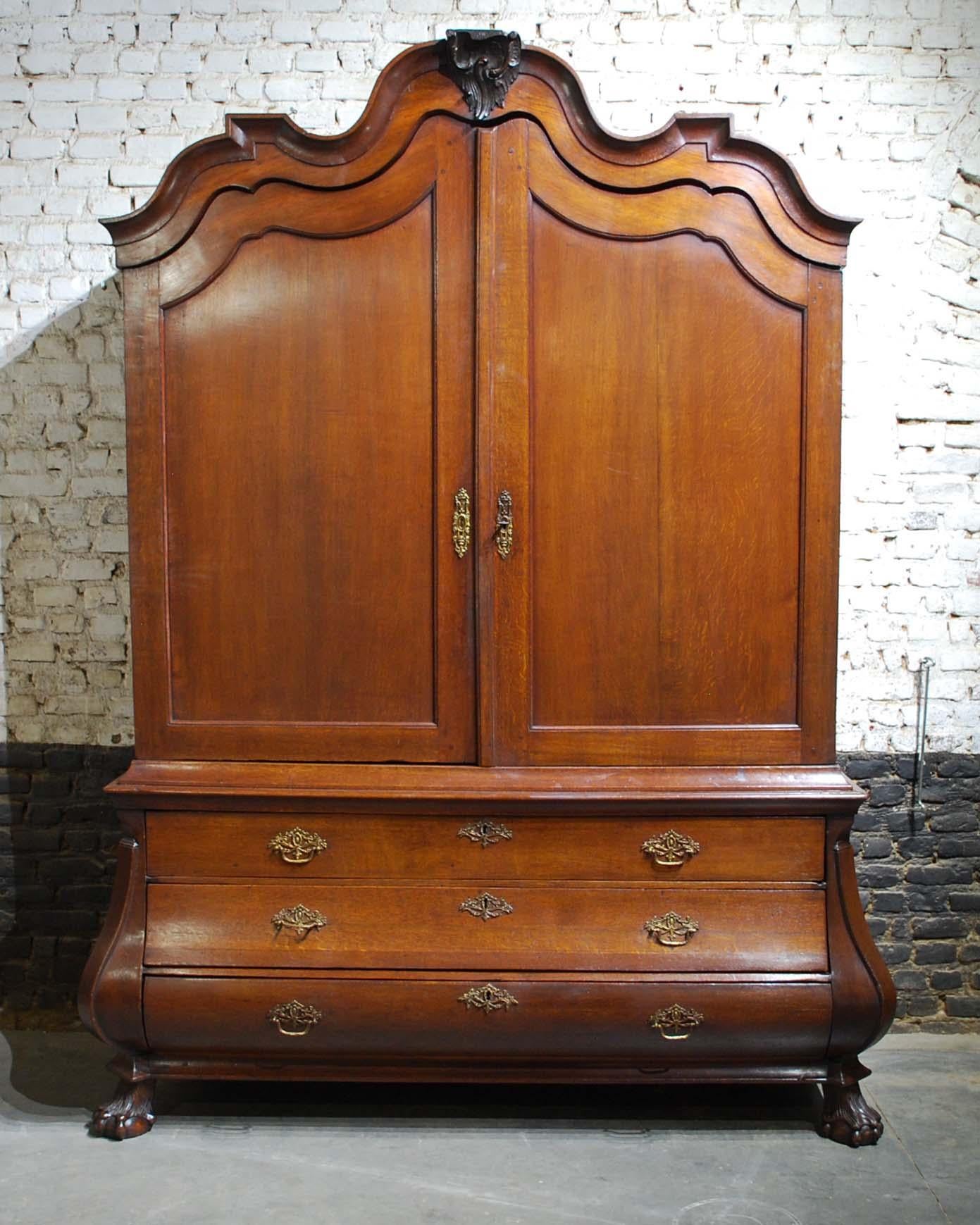 An elegant Dutch cabinet or cupboard that was made in The Netherlands, circa 1820s.
It was completely made in the best quality fine European oak. It has a bombe base ending on claw and ball feet. The base houses 4 drawers each with the original