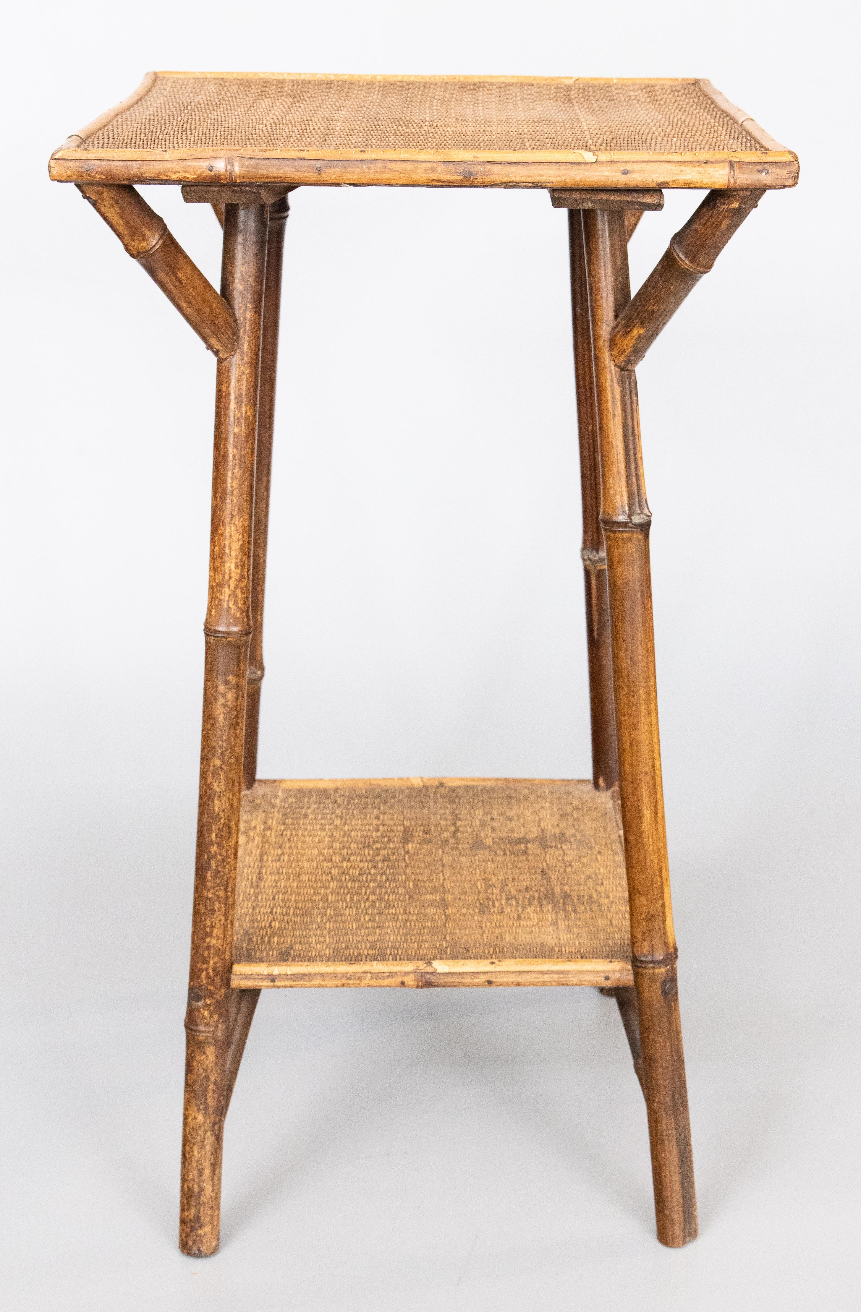A superb antique late 19th-Century English bamboo square two tier side table. This fine table has the original lovely woven grasscloth top and lower shelf. It's perfect as an end or accent table and it would make a fabulous addition to any
