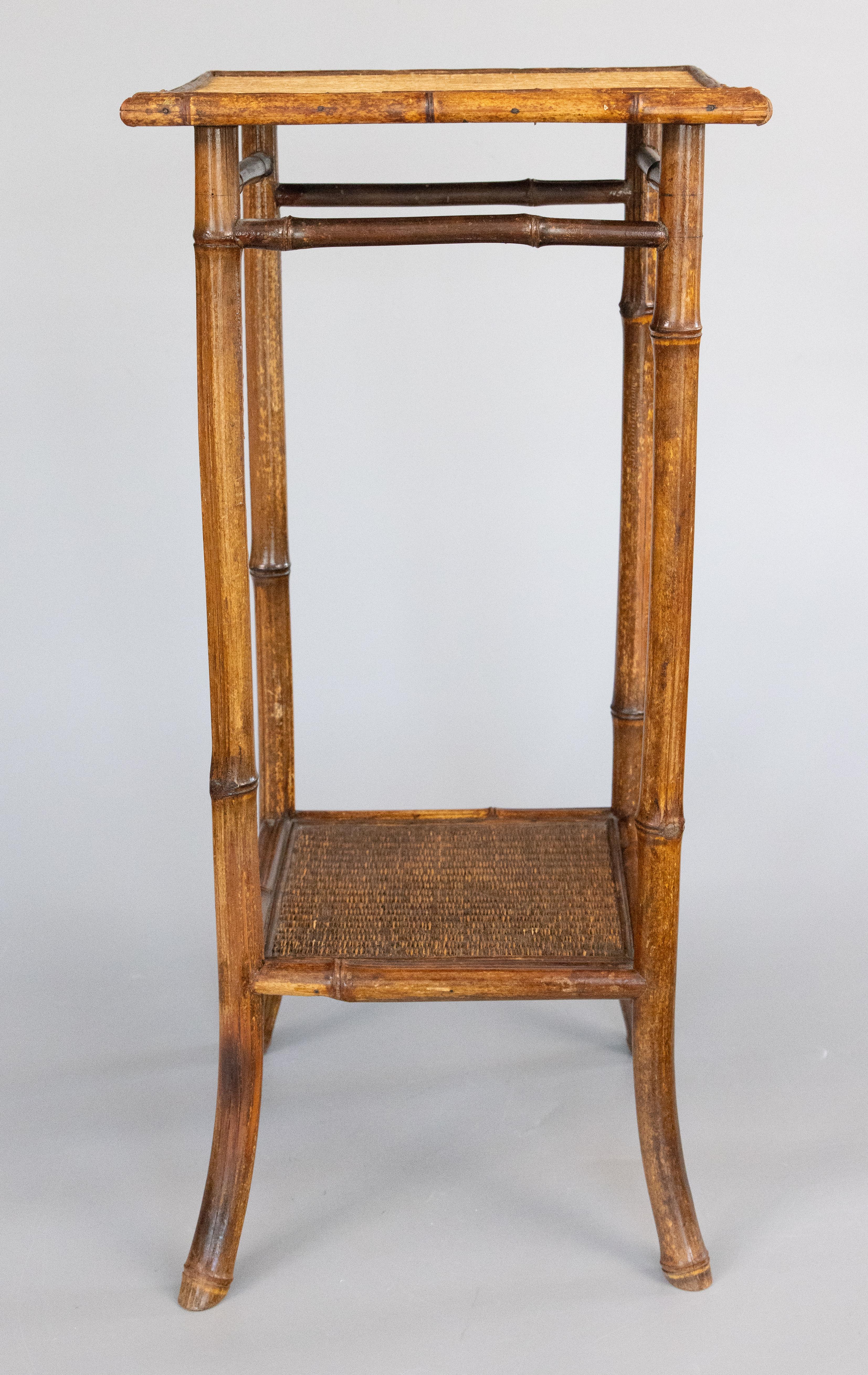 Superbe table d'appoint en bambou anglais de la fin du 19e siècle, carrée à deux niveaux, destinée à recevoir des boissons ou à être utilisée comme table d'appoint. Cette belle table possède un plateau en toile d'herbe tissée d'origine et de