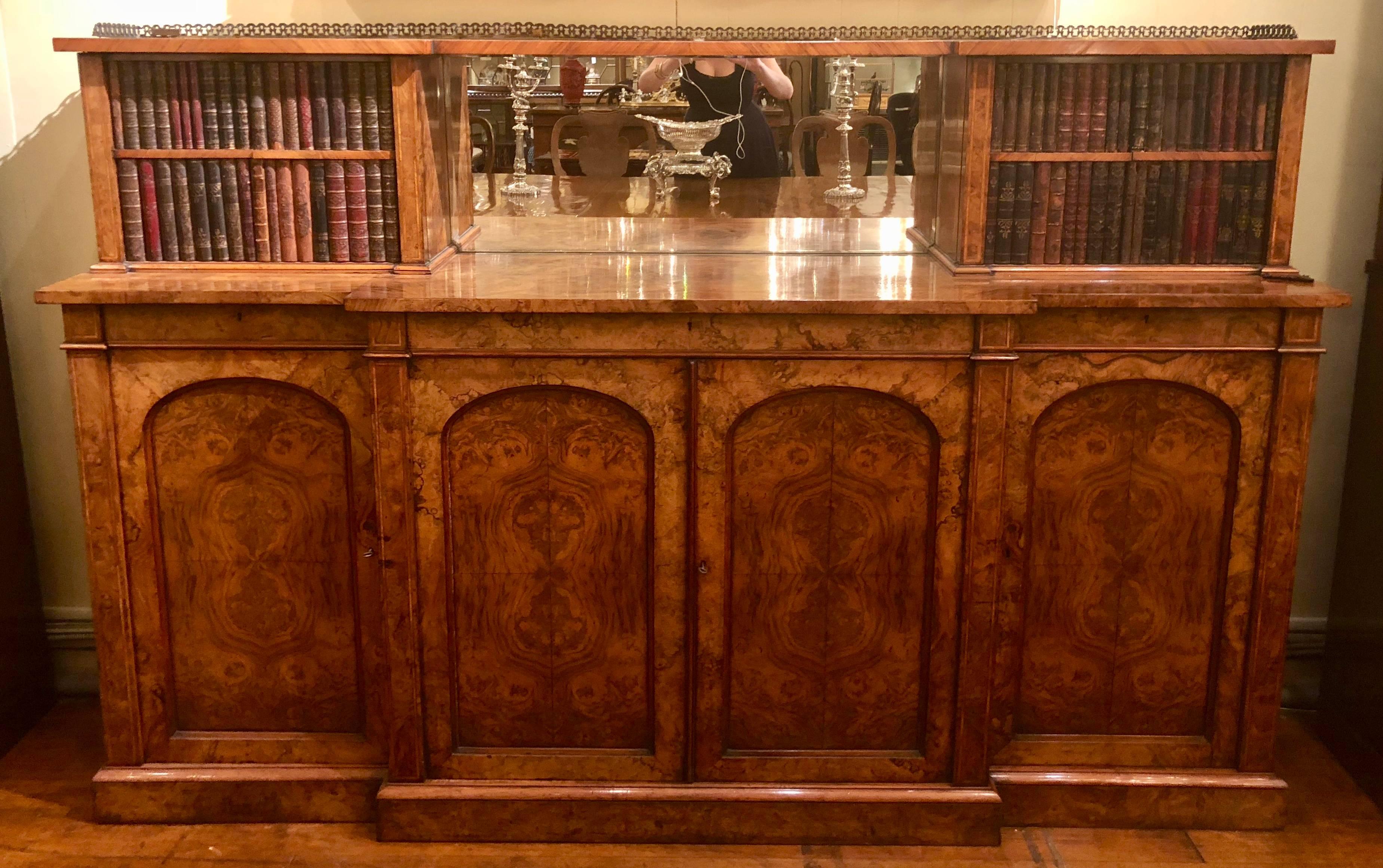 This is a very handsome burled walnut buffet. The top side cabinets look as though they are old book spines, but they are actually carved wood. As is true of many burl pieces, the movement in the wood is amazing.