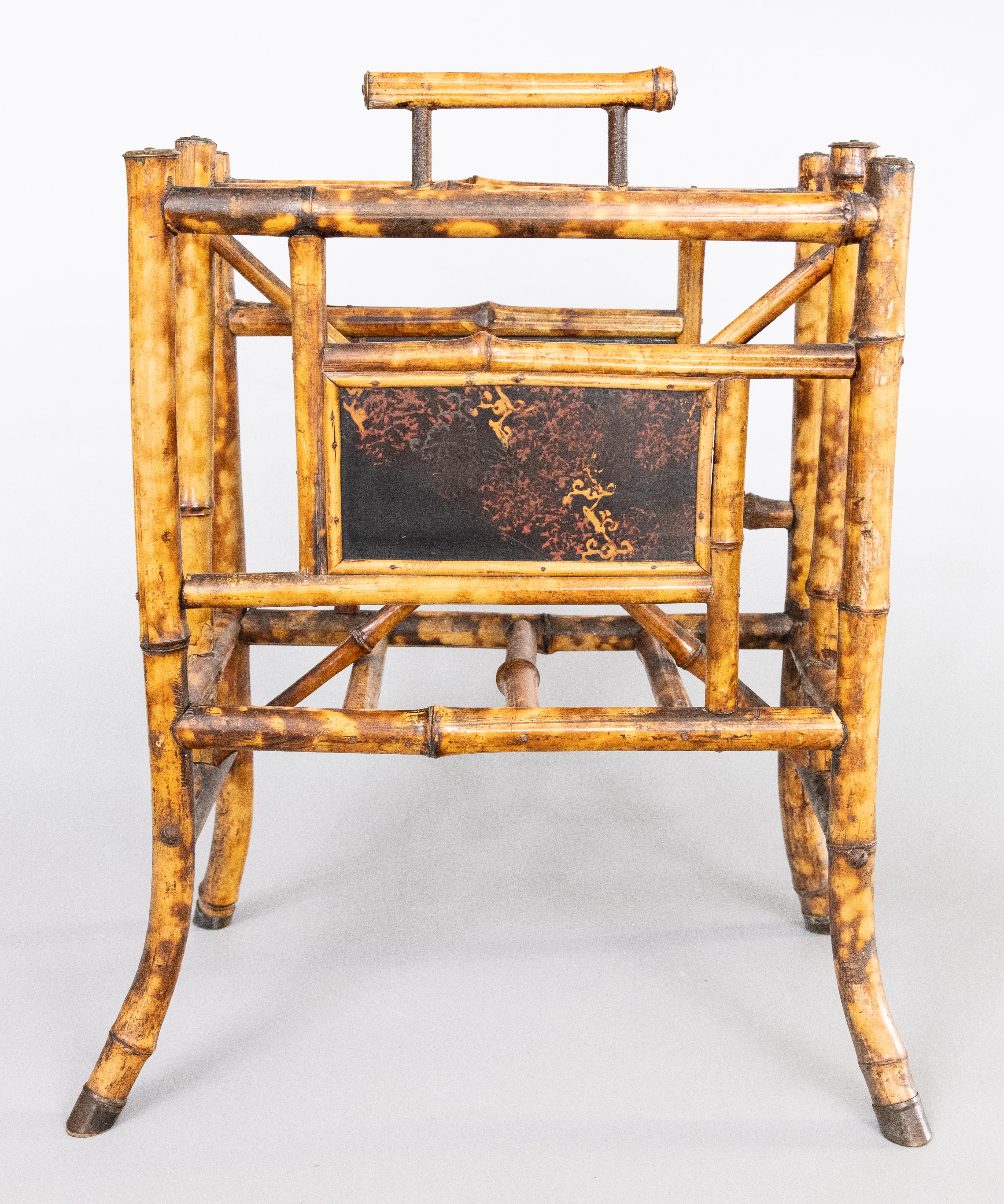 Un elegante portariviste inglese in bambù con pannelli decorativi laccati in stile giapponese, circa 1880. Sulle punte dei piedi c'è il timbro 