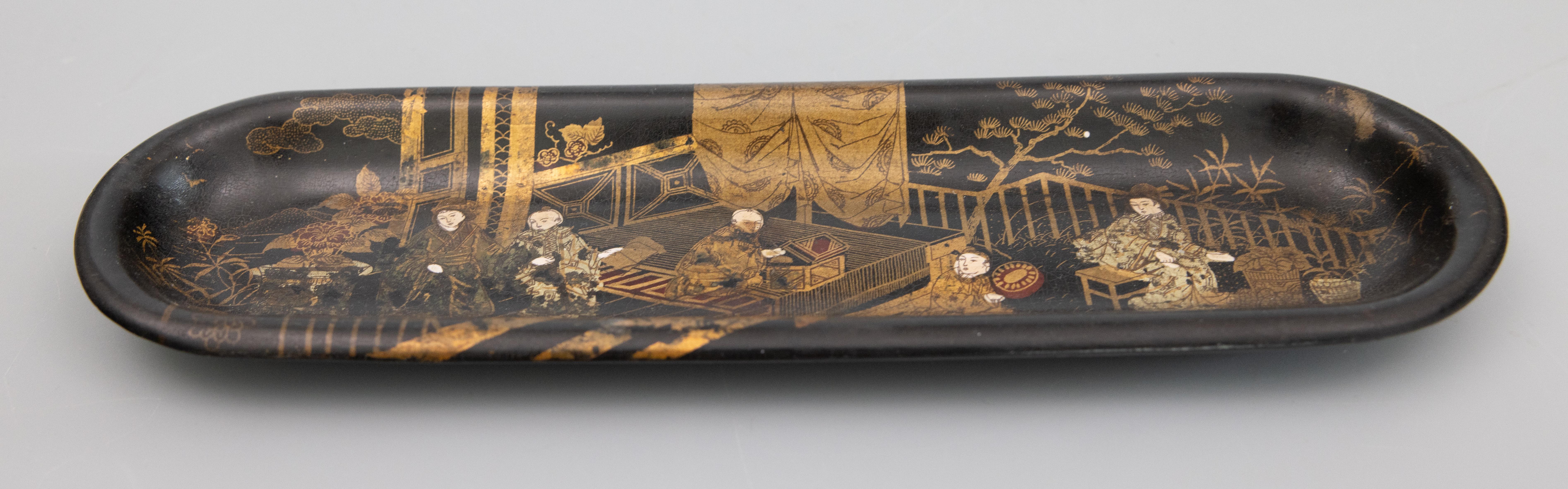 A superb antique English papier mache pen tray with an Asian chinoiserie design. It is hand made depicting hand painted gilt figures in a garden pagoda scene with Japanese maples on a black ebonized background. It would make a fabulous gift and be a