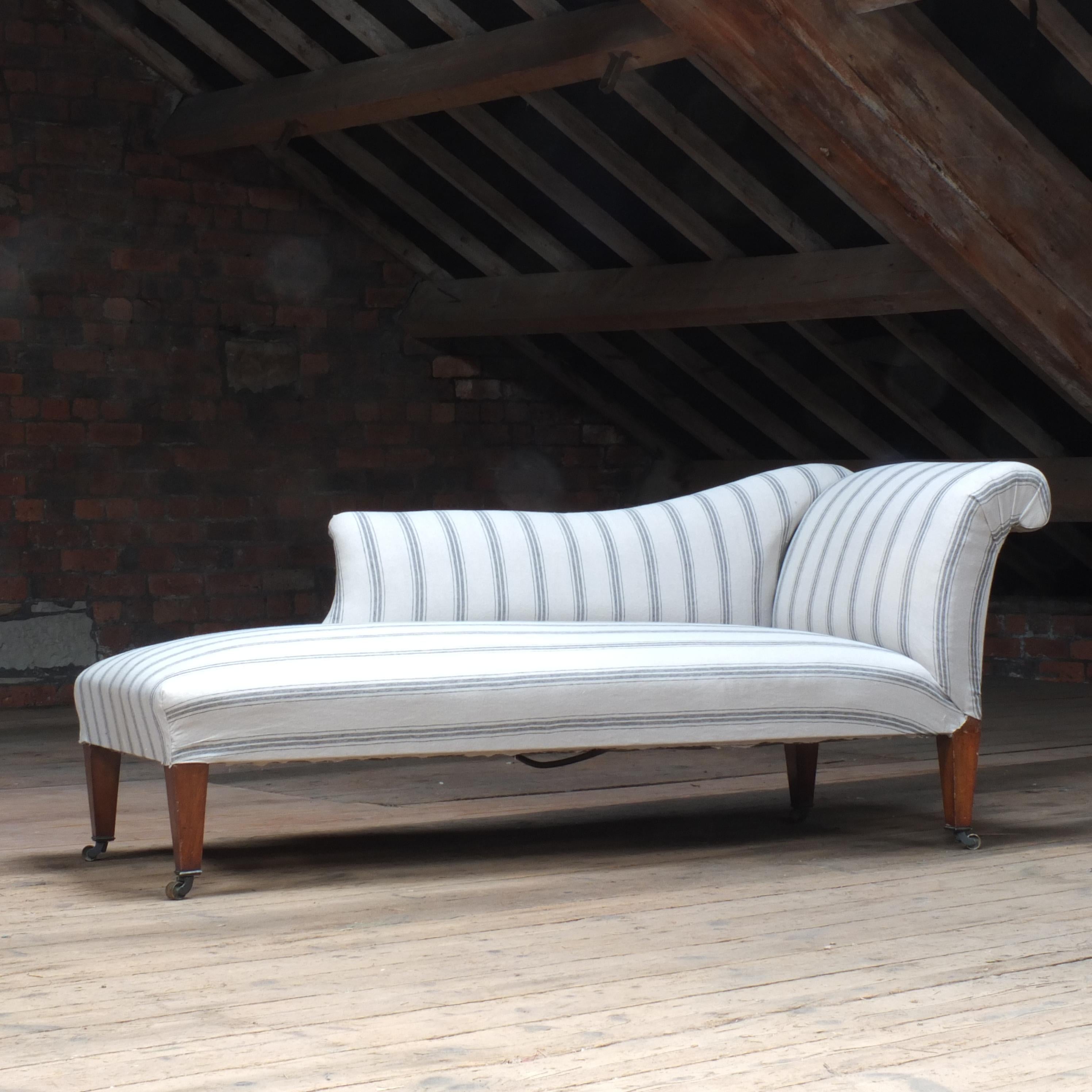 A large late 19th century chaise lounge raised on 4 square tapered legs with good quality original brass castors. In good solid structural condition throughout and just needing upholstery. 

The current fabric has been loosely fitted for