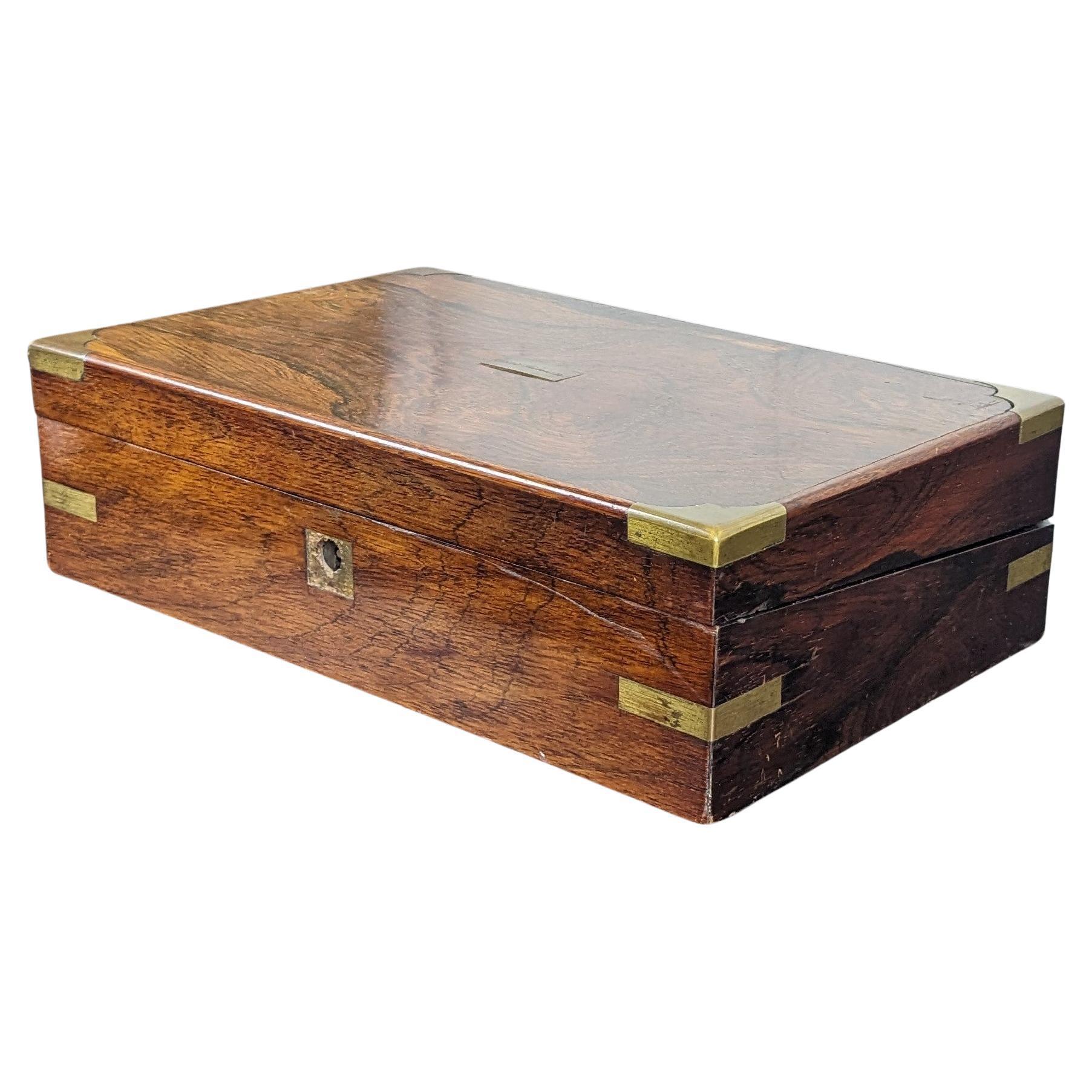 Antique 19th Century English Georgian campaign writing slope, box or travel desk.  Made of walnut feautring rectangular form with brass banding.  Opens to purple velvet interior with multiple storage compartments and writing surfaces.

At one point