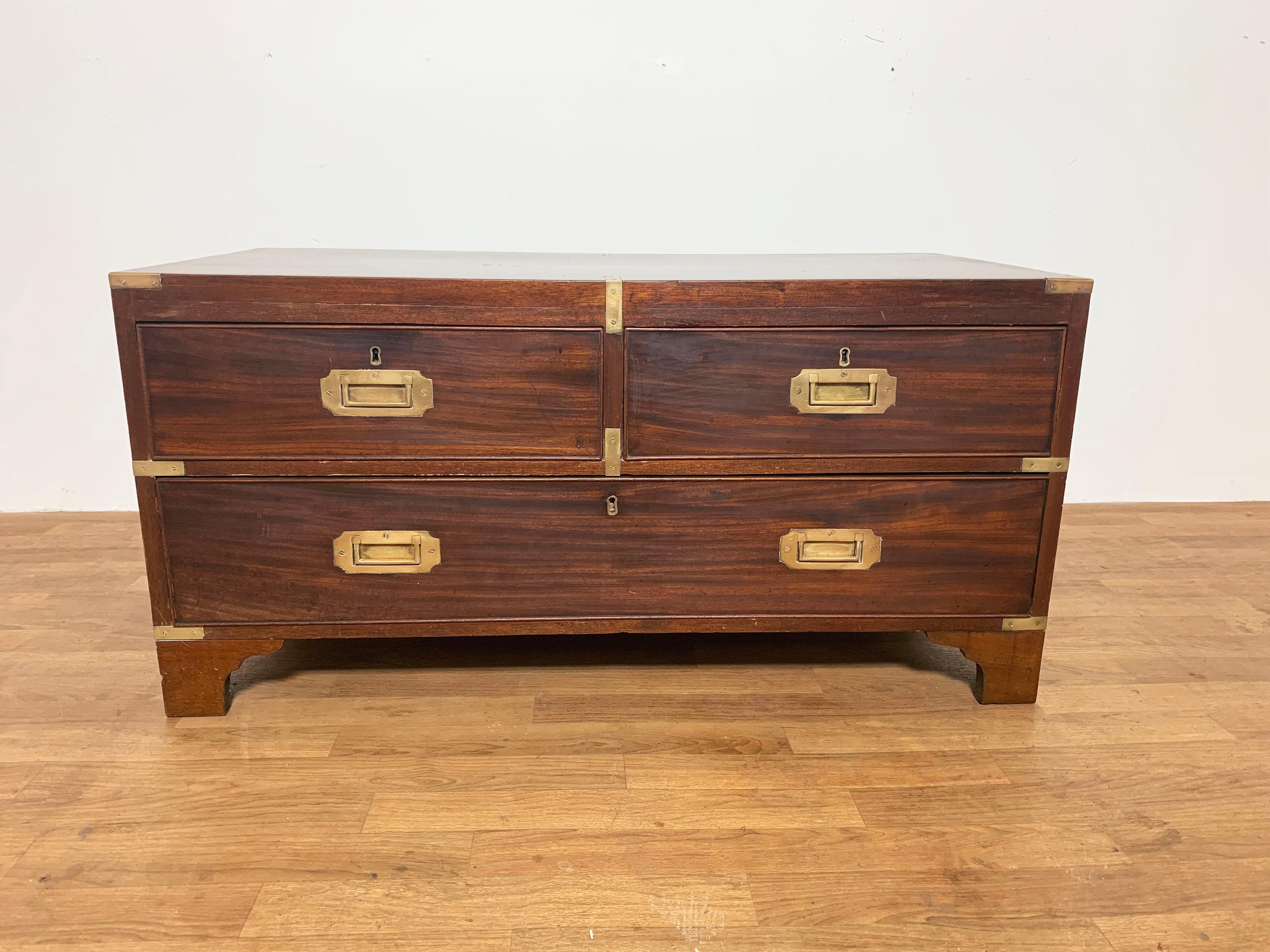 Low mahogany chest of two drawers once served as a trunk platform but is the perfect height for a modern coffee table. It dates to the 1870s. The unfinished back still bears remnants of a label from a 19th century furniture warehouse in Cheltenham