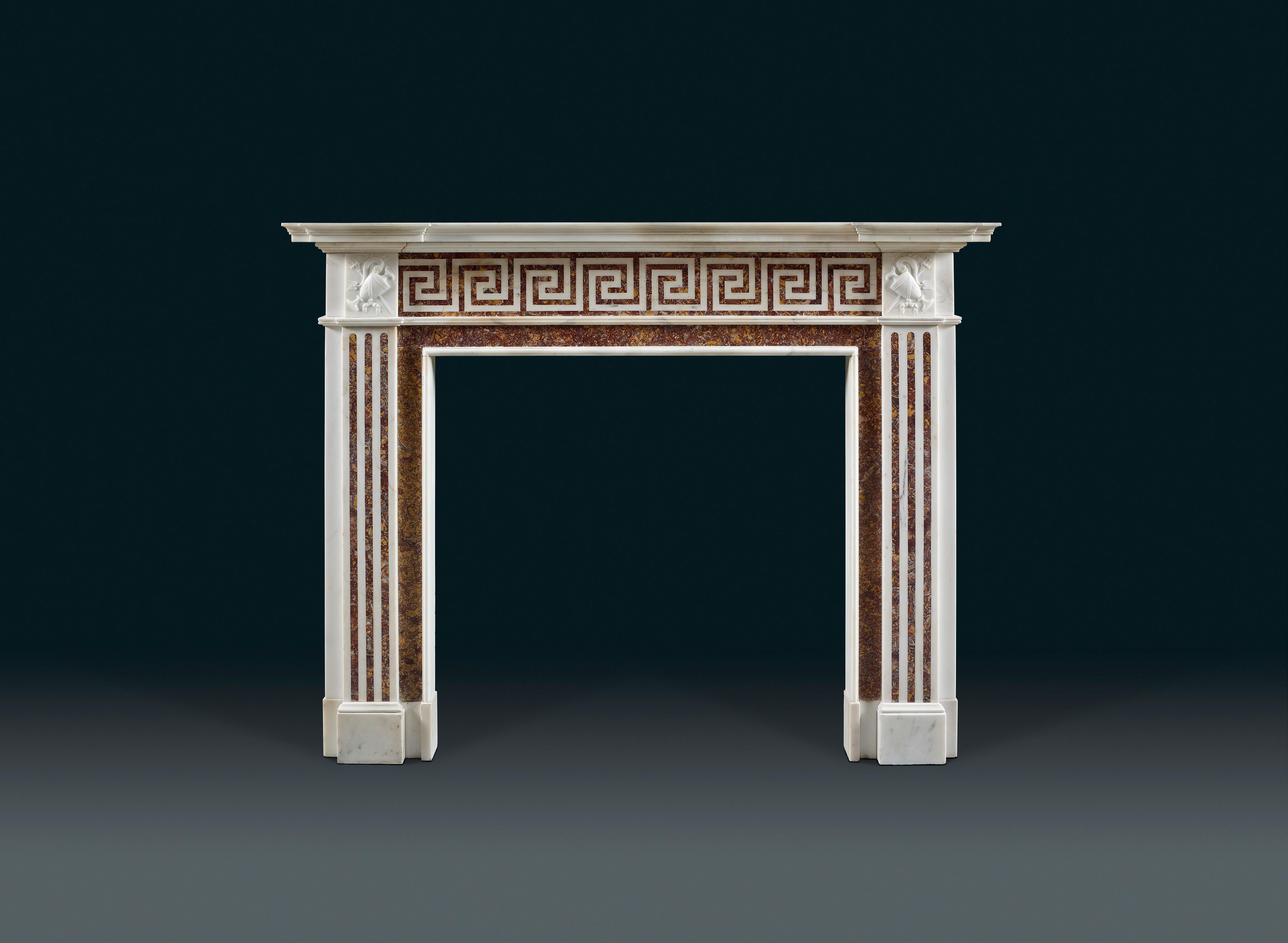 A 19th century English neoclassical chimneypiece of white statuary and colored Spanish Brocatello marbles. The tiered moulded shelf above the rectangular shaped frieze inlaid in white with a continuous double Greek key fret on a red and yellow