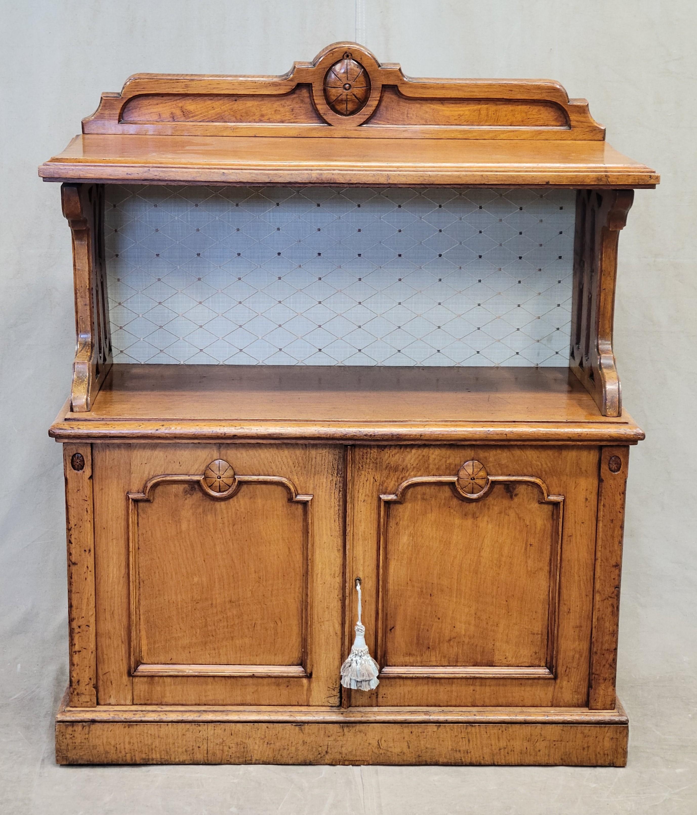 A beautiful antique English or Scottish golden elm server or bar with hand carved elements and a muted blue green diamond pattern fabric back panel. The old elm wood has gorgeous graining and just glows! Hand carved in the latter part of the 1800s