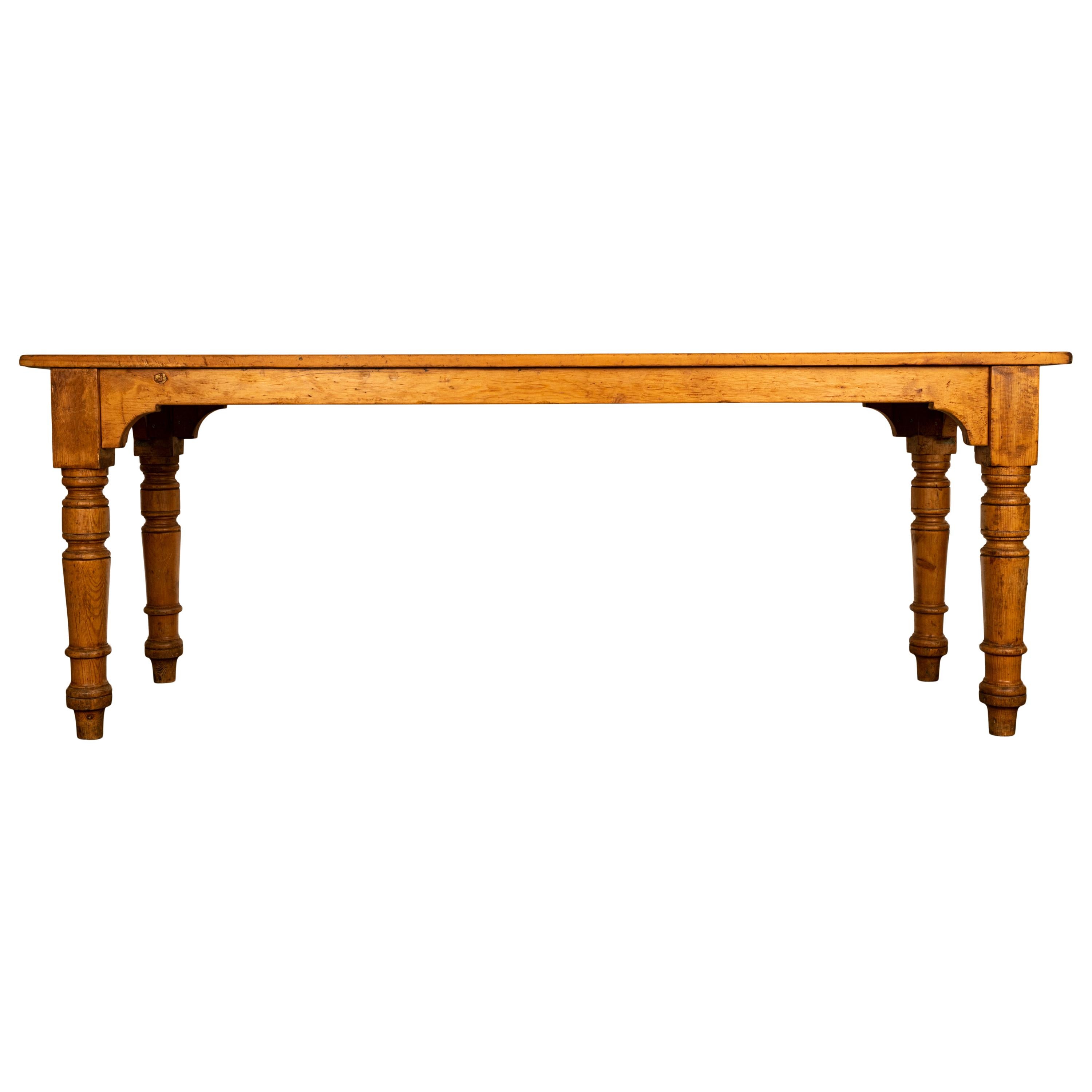 A good antique 19th century pine 7' country farmhouse pine table, circa 1860.
The long table is made of pine and is raised on four turned legs, the table skirt is arched on each side, the table top is made up of three long planks, the table has a
