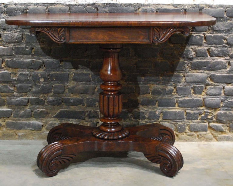 A beautiful English occasional or side table with a solid mahogany top that stands op a turned central baluster shaped column.
The central column ends in a quadriform platform with scrolled feet. The platform base is made in solid oak, with
