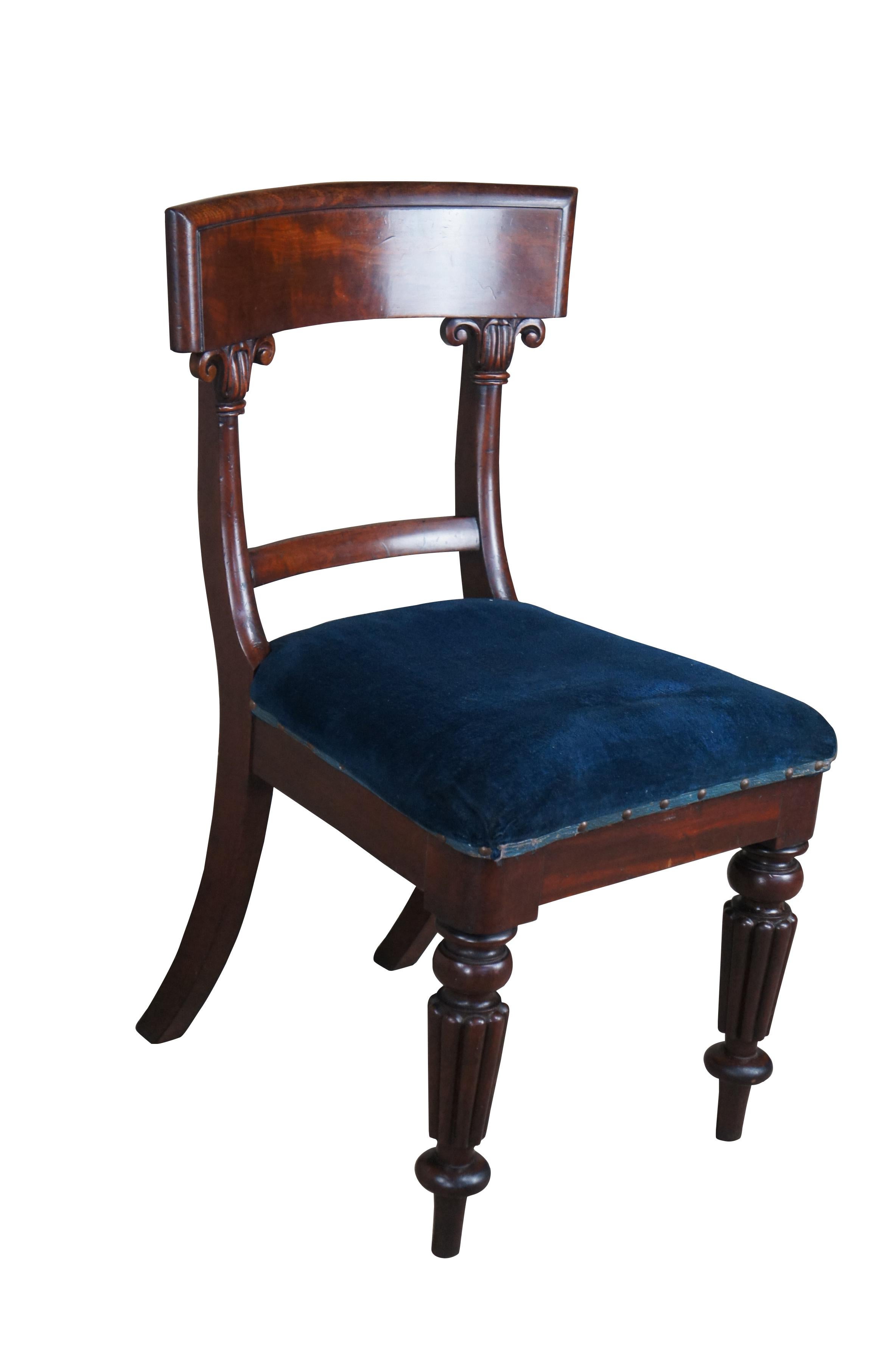 An exquisite English Regency chair from the first half of the 19th century.  Made from mahogany with a contoured crest rail, ornate embellishments and blue upholstered seat.  The chair is supported by Reeded legs with arrow feet along the front and