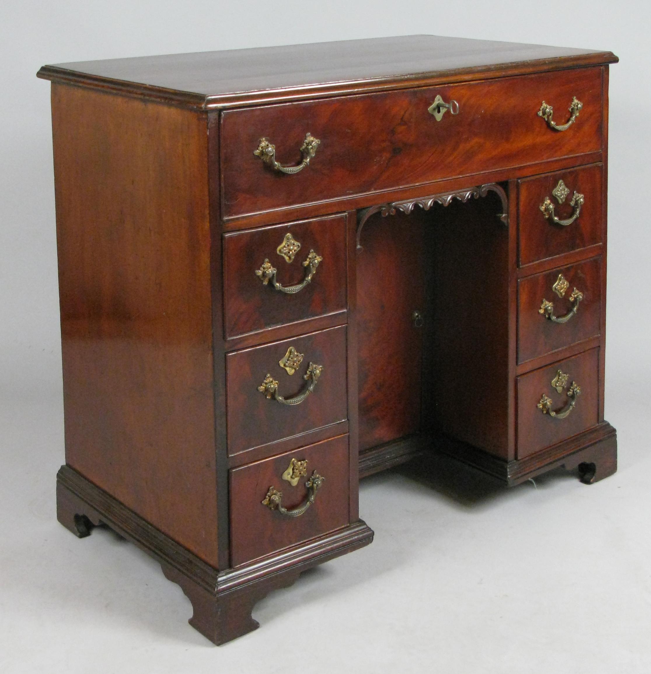 A beautiful antique English mid-19th century Georgian writing desk, with lovely scrolled base, and a locking interior cabinet in the kneehole.