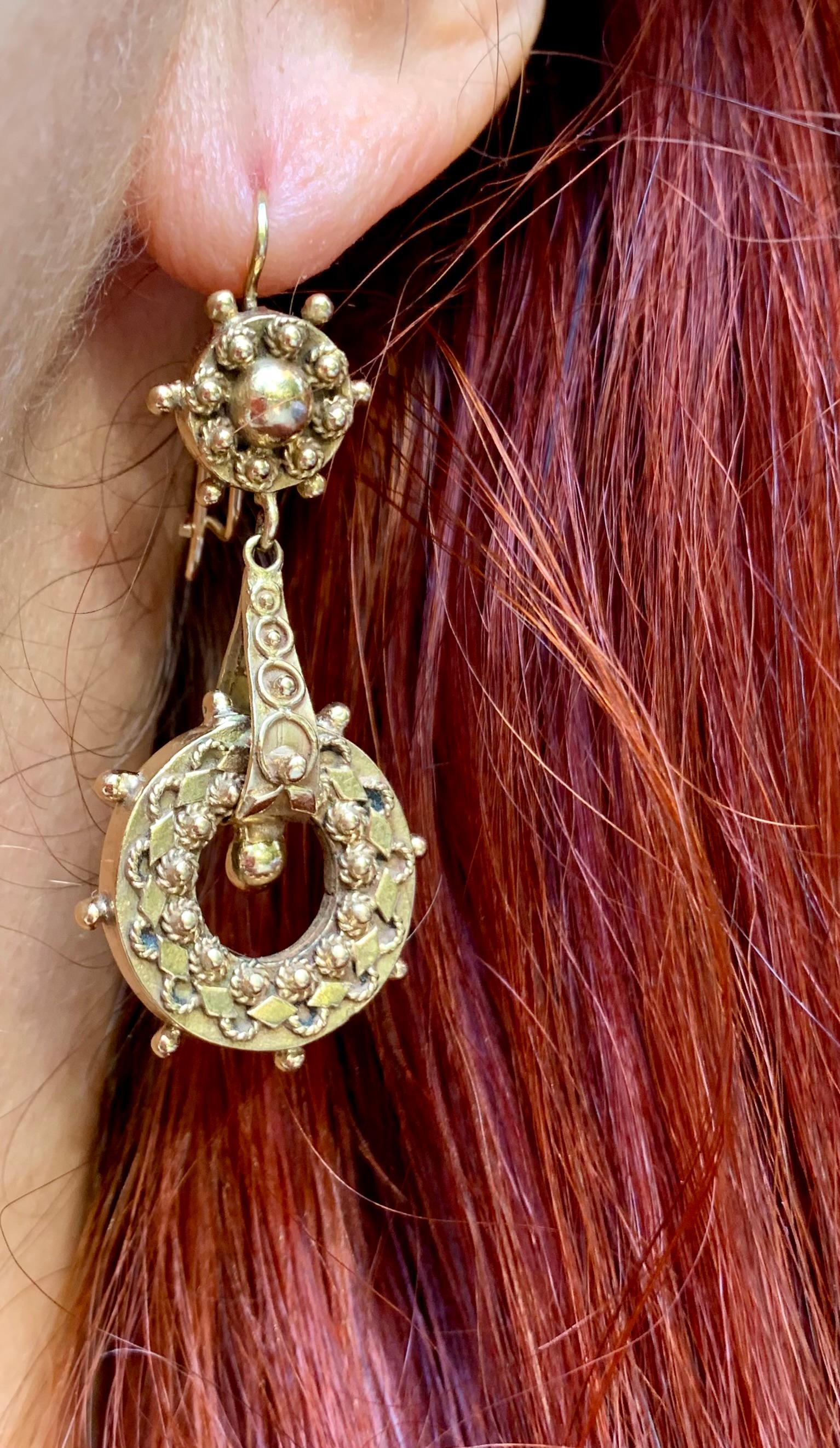 Orecchini antichi del XIX secolo in oro giallo 14 carati di tipo Etruscan Revival con tecniche di decorazione a granulazione e a filo ritorto.
Grandi e sostanziosi orecchini pendenti in oro, ognuno dei quali è composto da tre sezioni che permettono