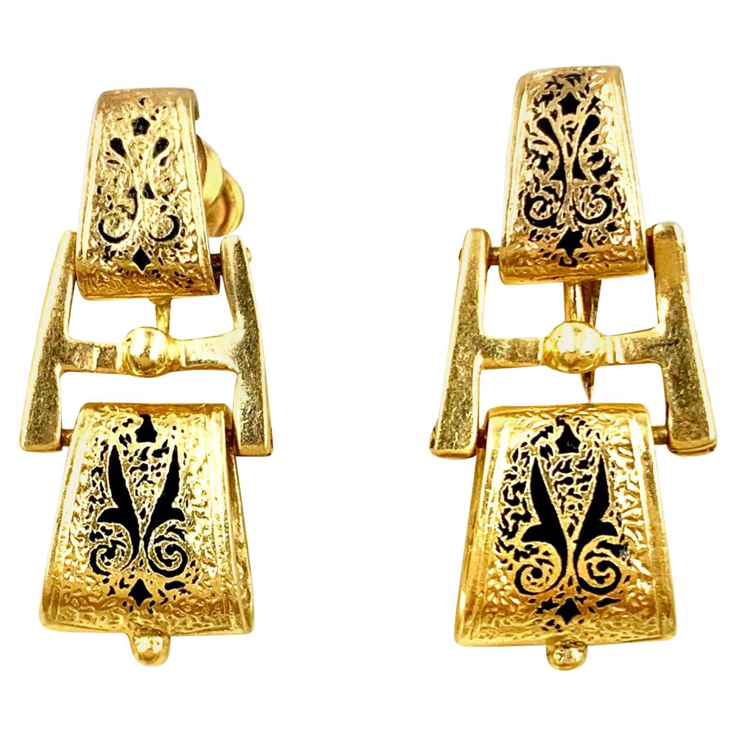 Boucles d'oreilles pendantes en or jaune 14K et émail de style néo-étrusque
19ème siècle
Ces magnifiques boucles d'oreilles sont ornées d'un décor détaillé en émail noir représentant des motifs d'ailes stylisées, des rinceaux et de délicates fleurs.