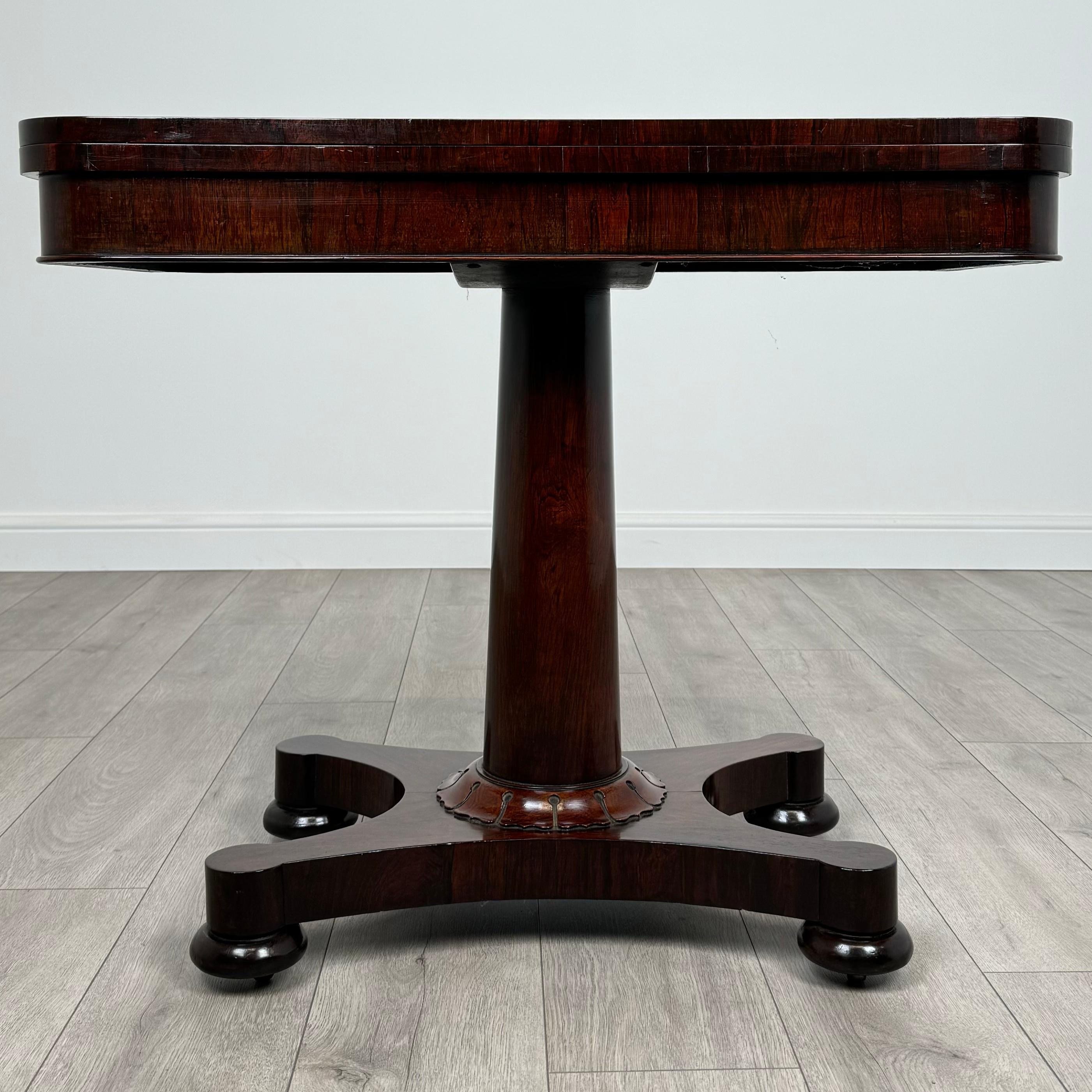 Cette superbe table à cartes du XIXe siècle, fabriquée en riche bois de rose, est un magnifique exemple d'artisanat ancien. 
D'excellente qualité et en très bon état, cette pièce allie élégance et fonctionnalité. La table présente un intérieur en