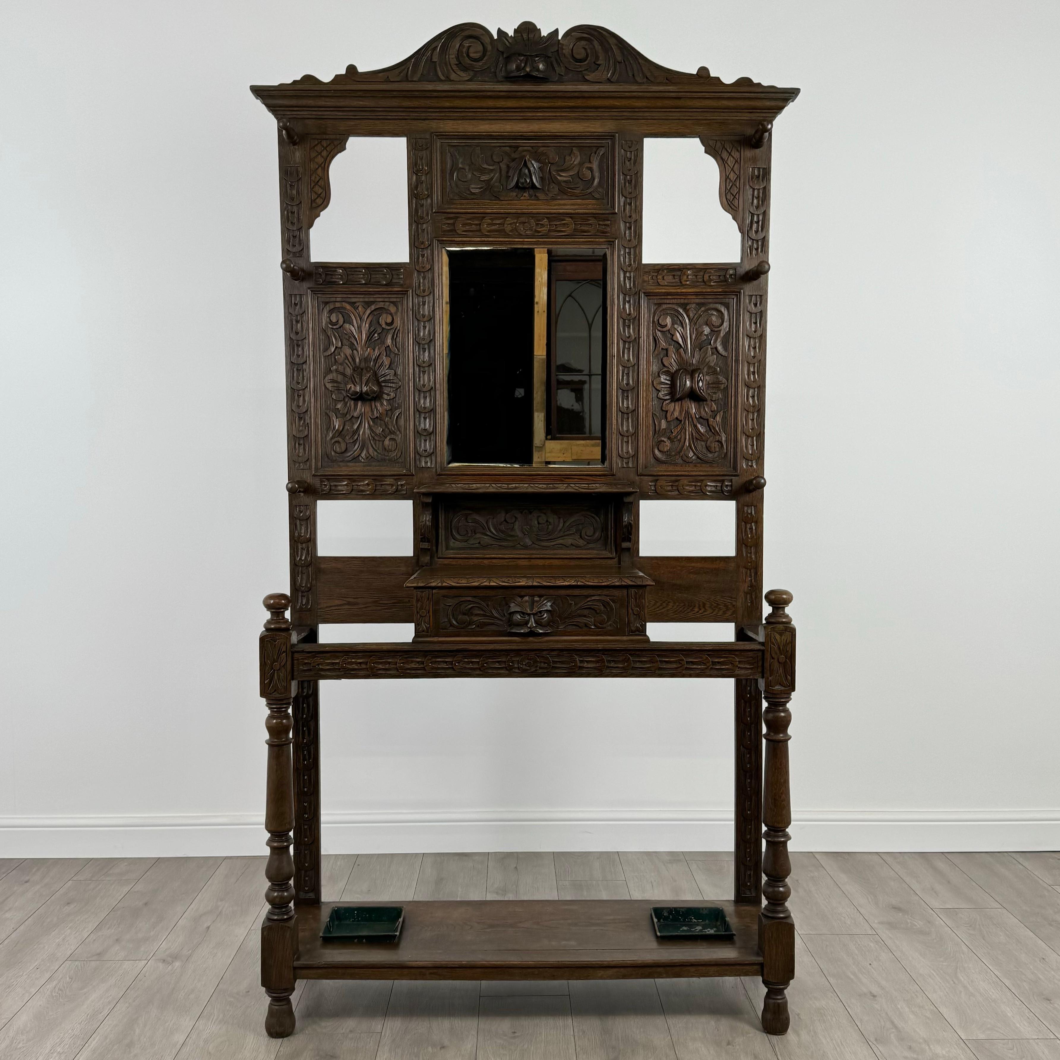 This antique 19th-century hall stand, crafted from solid oak, is a truly exceptional piece of furniture, beautifully decorated throughout with intricate and detailed carvings. A fine example of craftsmanship, it exudes elegance and functionality,