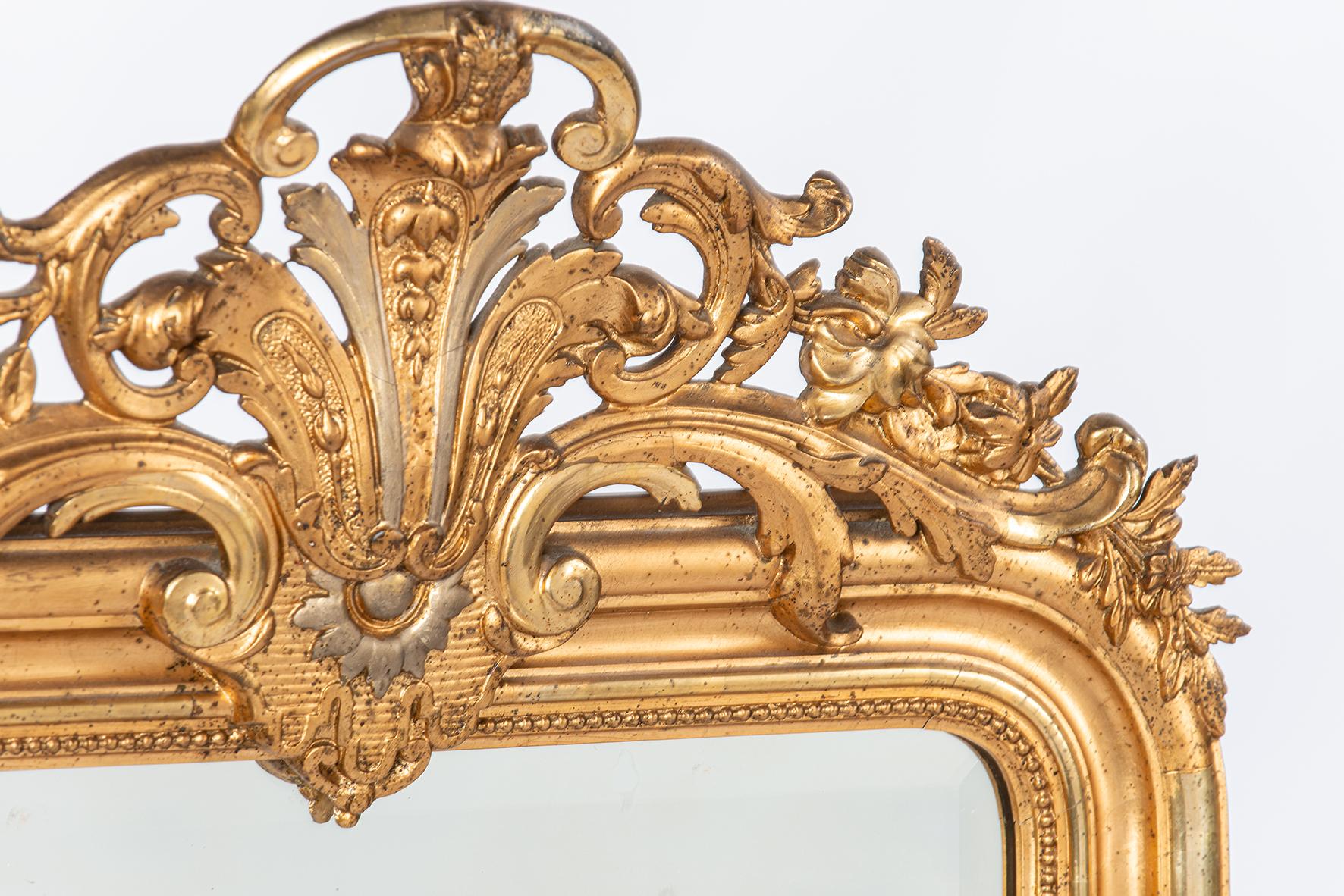 Este impresionante espejo francés antiguo, fabricado hacia 1850 en la región de Alsacia, es un notable ejemplo del estilo Louis Philippe. El espejo está ricamente decorado y muestra una artesanía exquisita, con un impresionante escudo y ornamentos