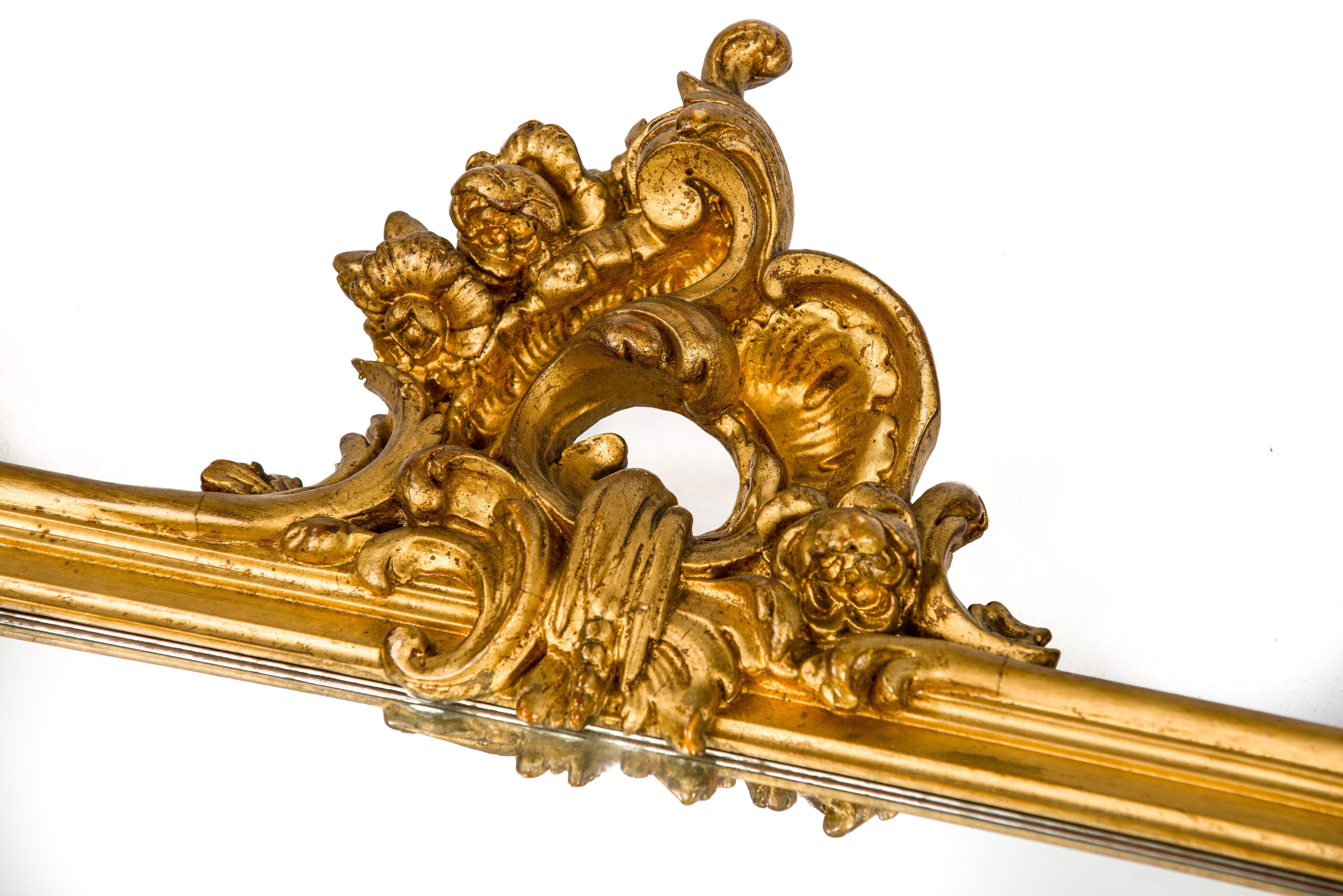 Ce beau miroir rectangulaire doré est fabriqué en France, vers 1870.
Le cadre est décoré d'ornements baroques très détaillés tels que des volutes de C, des acanthes, des fleurs et des feuilles. Le cadre a une base en pin lissée au gesso et est
