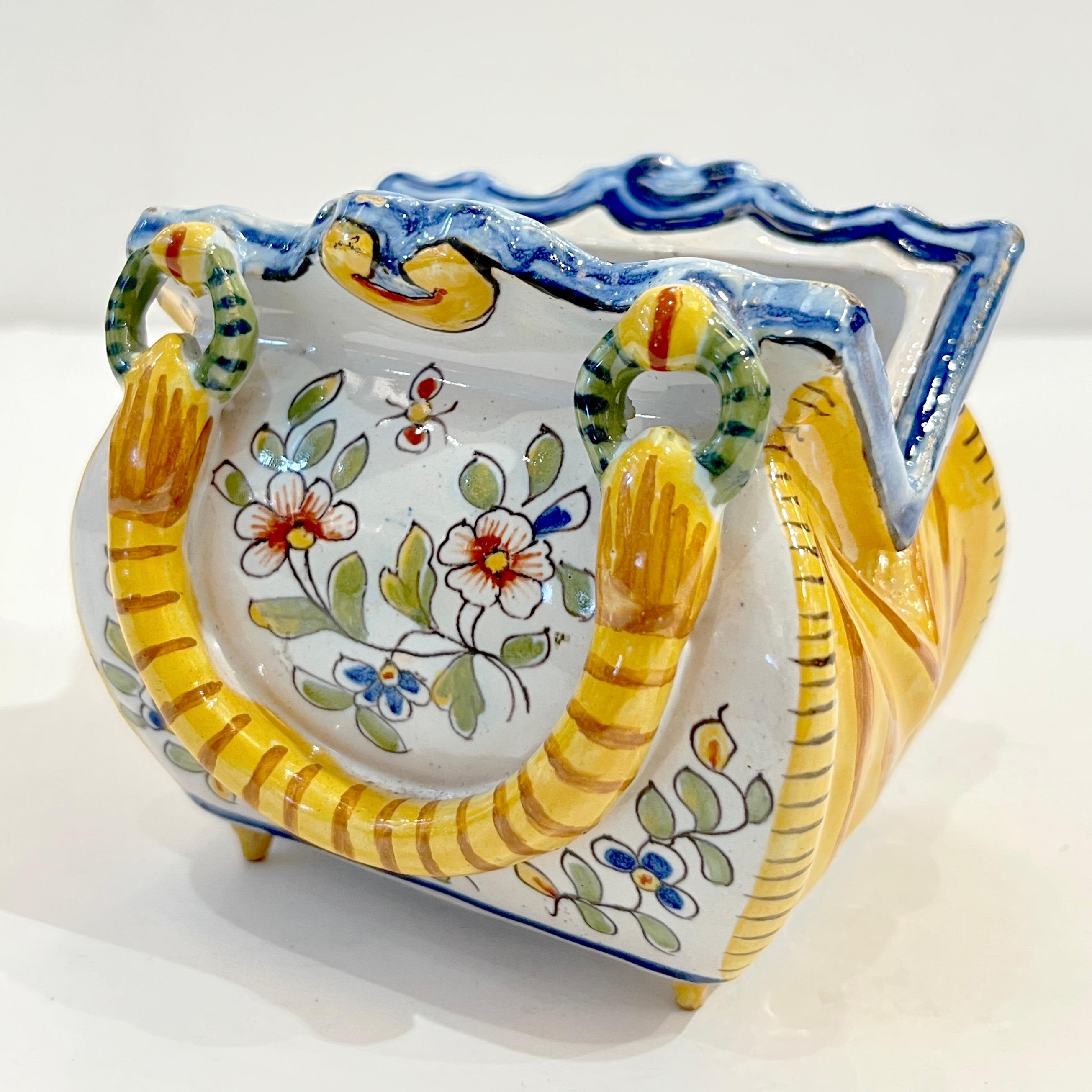 Charmant et rare vase en forme de bourse en faïence de Desvres, signé par Émile Fourmaintraux, l'un des artisans les plus importants de l'atelier historique de la famille Fourmaintraux. Cette exquise pièce en majolique peinte à la main capture